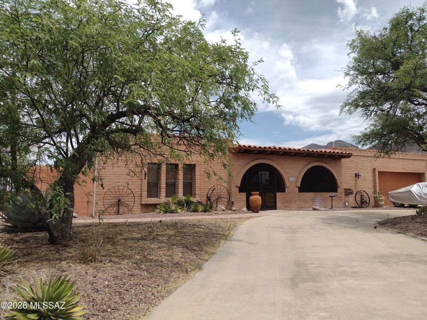 Mountain views and stunning Arizona sunsets surround this private retreat on nearly 2 acres! This spacious brick home offers timeless curb appeal with low-maintenance durability and a peaceful setting perfect for relaxing or entertaining. The kitchen features custom hickory cabinets, tile countertops, stainless steel appliances, and a built-in trash compactor, opening to a cozy family room with fireplace. Large-format tile flooring and ceiling fans throughout provide year-round comfort. Expansive Arizona room with swamp cooler adds flexible living space. Roof recently recoated with 2-year warranty. Oversized 2-car garage offers abundant storage/workspace plus RV parking and extra parking. Large patio, charming front porch, and spacious side yards complete this classic Arizona retreat!