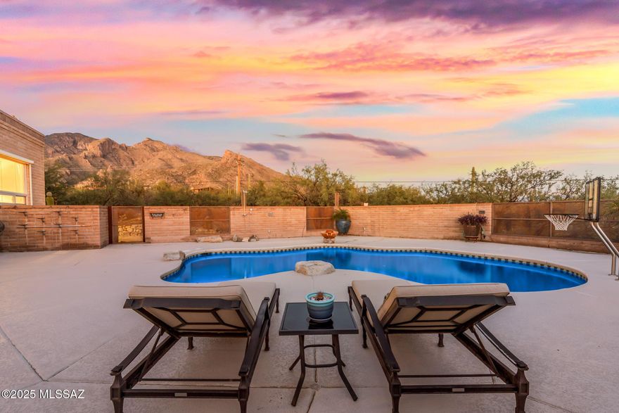 Sweeping City Lights and Mountain Views Frame this updated territorial block retreat perched high on a huge elevated cul-de-sac lot in the Foothills. Thoughtful 3 bed +den layout is Fully and Expertly updated! Solid cherry: cabinets, doors and trim! Dual-paned windows w/ remote shades, multiple built-ins, ample storage. Expansive primary offers bonus room, dual closets and picture window framing the panoramic view. Kitchen shows off with rare stone, a coffee station and entertainer's island with wine bar and dining counter. Open living room with fireplace, NEW fully equipped, garage retreat. Outdoor oasis has huge covered patio, kitchen, 2 grills, sparkling pool, waterfall, outdoor shower & multiple lounging spaces for effortless entertaining w/ unrivaled views. Too many upgrades to list!