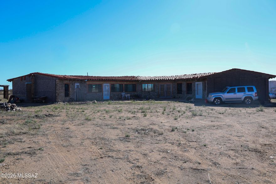 Highly Sought after RU-4 zoning, 40 acres high desert, distinctive owner-built home -offers privacy, character, and the opportunity for self-sufficient living. Designed for off-grid living, the property includes solar panels with 6 batteries, a backup generator, a private well with 1500 gallon storage tank, pressure pump inside & pole barn. Approx. 2,800 sq ft home has a unique half-octagon design that brings in natural light through 24 large windows.
Interior showcases vaulted tongue-and-groove wood ceilings, exposed beams, natural stone accents, and terracotta tile flooring, creating a warm southwestern feel. The spacious kitchen includes wood cabinetry, tile countertops, bar seating and a large center island, dishwasher, electric stove and cooktop. A library-style hallway with built-in shelving adds character and function. The home includes 3 bedrooms (2 rooms/ 1 Studio sleeping area) and 2 bathrooms, with one bedroom currently used as a workshop.  Construction to 2nd bathroom and outside of home will need to be completed by the new owner.

Everything in the Home and On the Property will Stay and CONVEY to the new owners.  There is and RV and Trailer that we will provide the Titles to at Close of escrow.  NOTHING is being Removed. CASH ONLY, not owner Financing.   Septic System was built and design was filed and approve by Cochise County, but owner did NOT follow through with permitting and design was not followed. - Buyer to have a Septic company give quote for corrected design during inspection period.  Seller will NOT correct the issues and Buyer will have to sign HOLD HARMLESS documentation taking on responsibility AFTER closing.