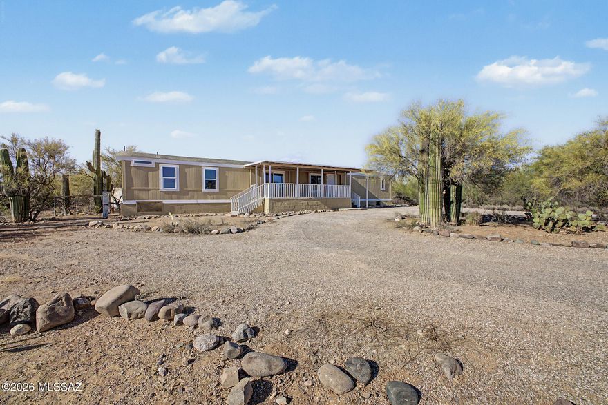 Magnificent fully remodeled manufactured home on a sprawling acre of peaceful desert landscape! This move-in ready retreat blends modern style with serene Arizona living, featuring tasteful upgrades throughout and an inviting open layout filled with natural light. Step outside to an amazing oversized deck perfect for enjoying breathtaking desert views, colorful sunsets, and beautiful weather year-round. Plenty of space to relax, entertain, or create your dream outdoor oasis. Conveniently located close to shopping, dining, and everyday amenities while still offering the privacy and tranquility of country-style living. A rare opportunity to enjoy the best of both worlds!
