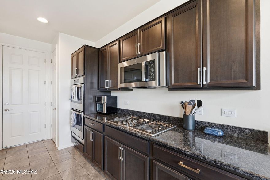 In Rancho Sahuarita Community, this home has a spacious 3-bedroom, 2.5-bathroom layout with a loft. It features an ASSUMABLE LOAN at 4.375% interest. The home offers a great room concept with 9' ceilings, neutral stone and tile flooring, and abundant natural light. The gourmet eat-in kitchen has espresso cabinets, granite countertops, a breakfast bar island, a reverse osmosis system, and a water softener. The refrigerator, washer, and dryer are included. Outside, the large private backyard overlooks the natural desert, has only one adjacent neighbor, and features a covered patio, professionally installed pavers, and artificial turf. This is a must-see! At this price and interest rate, it won't last long!