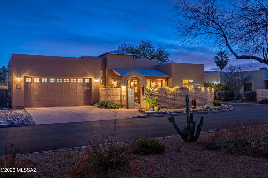Situated within the gated enclave of The Garrison in the Old Fort Lowell Historic District, this architecturally compelling territorial residence offers a rare combination of privacy, authenticity, and elevated desert living. A graceful arched entry introduces a private, walled front courtyard, immediately establishing a sense of arrival. Surrounded by warm masonry walls and layered desert landscaping, the courtyard is designed as an intimate outdoor gathering space, complete with ambient lighting and a covered north facing veranda. This area serves as both a retreat and a refined prelude to the interiors beyond. Inside, the home reveals dramatic scale and architectural character. Soaring ceilings articulated by exposed wood vigas create volume and visual interest, while clerestory windows draw in natural light with intention. Stained concrete floors extend throughout, grounding the residence in a modern sensibility that complements textured and neutral-toned walls with softly sculpted corners. The Great Room unfolds as the central gathering space, seamlessly connecting living and dining areas. Expansive picture windows and glass doors frame courtyard views and reinforce the effortless indoor outdoor flow that defines the property.

The kitchen is both striking and functional, anchored by solid wood cabinetry, slab granite countertops, and a diagonally set porcelain  backsplash. A professional grade stainless steel gas range and hood command attention, complemented by premium appliances and a generous peninsula with an integrated sink and bar seating. A built-in desk provides additional versatility while maintaining a cohesive design narrative.

The bedroom wing is thoughtfully arranged for privacy and flexibility. The office or third bedroom features custom built-in wood cabinetry with an integrated Murphy bed, allowing the space to transition seamlessly between executive office and guest suite. French glass doors open directly to the front courtyard, enhancing its connection to the outdoors. On the southwest end of the residence, the primary suite offers generous proportions, soft southern facing natural light, and direct access to the rear patio. The spa inspired bath is appointed with a soaking tub set within a tiled surround, a separate glass enclosed shower with decorative tile detailing, dual vanities, and expansive counter space. On the southeast end, the guest bedroom provides comfortable separation and is paired with a beautifully finished ensuite bath with coordinated tile work and elevated finishes.

At the rear of the home, the primary entertaining courtyard unfolds as a dynamic outdoor living environment. Brick paver patios, raised planters, banco seating, and multiple lounge and dining areas create a layered, resort like setting, with curated landscaping and soft string lighting elevate evening gatherings. Seamlessly connected to the interior through generous glass openings, this outdoor sanctuary becomes a natural extension of the home, embodying the sophistication and ease of refined desert living.