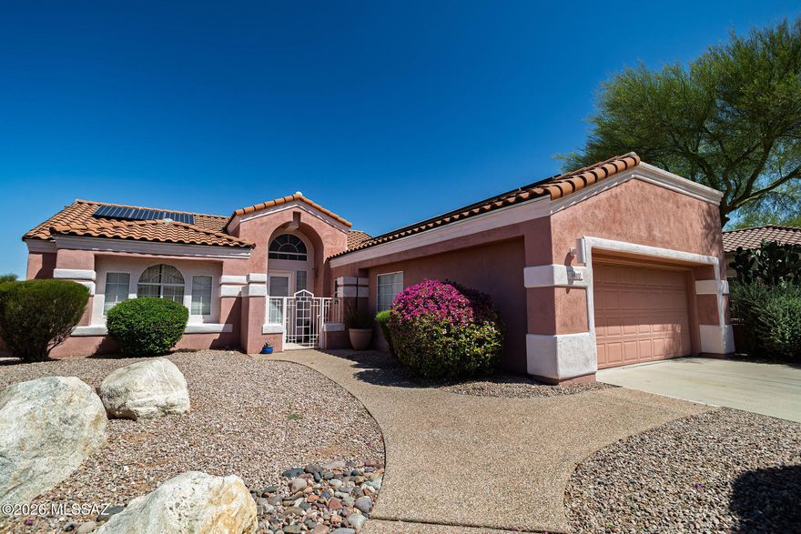Views, Views, Views. Located in the prestigious guard-gated community of La Reserve, this hilltop home offers breathtaking panoramic views of the Catalina Mountains, Pusch Ridge, the Tucson Mountains, Sombrero Peak, and the valley below. Perched on a premium view lot with no rear neighbors, you will enjoy incredible sunsets, privacy, and peaceful desert surroundings from the spacious rear patio and backyard.
The great room floorplan is filled with natural light and features vaulted ceilings, a floor-to-ceiling tiled gas fireplace, large picture windows, and updated flooring throughout. The kitchen includes stainless steel appliances, a breakfast nook, ample cabinetry, and access to the side patio. Adjacent formal dining area is perfect for entertaining.  Low electric bills with Free Solar The spacious primary suite offers stunning views, private patio access through a sliding glass door, a large closet, dual sinks, oval soaking tub, and an updated walk-in shower. The second bedroom/office/den features double-door entry and beautiful Pusch Ridge views, making it ideal for guests or a home office.
Additional upgrades include freshly painted interior, paid-in-full solar system, soft water system, newer roof in 2015, and no poly pipes. Charming features throughout include a gated front courtyard, brick paver patios, mature landscaping, citrus trees, arched windows, and exceptional outdoor living spaces designed to capture the incredible scenery.