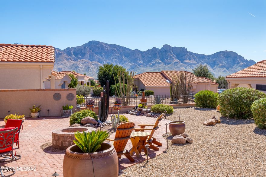 Charming 1,093sf 2BR/2BA Oasis floorplan in Sun City Oro Valley, situated on a fully fenced lot w/stunning mountain views. Inviting fully-fenced front courtyard features pavers. Paver driveway adds to the curb appeal. Kitchen has newer maple cabinets w/pull-outs, quartz countertops & stainless-steel appliances. Bay window in breakfast nook has beautiful mountain views creating the perfect setting for morning coffee. Wood flooring extends through most of the home with ceramic tile in the kitchen & guest bath. Updated interior doors & baseboards add a fresh, modern touch. 2nd bedroom features a built-in desk & sliding glass door to patio ideal for guests or home office. Both bathrooms have been tastefully updated. Covered patio has ceiling fan & remote-controlled sunscreens. Additional upgrades include newer roof (2017) w/gutters & Leaf Guard. Newer HVAC (2022). Extended brick walkway & firepit in the fully fenced backyard. Spacious side yard too! Garage has storage cabinets & epoxy-coated floor. This home is a true gem in a spectacular location! Enjoy all that Sun City Oro Valley has to offer, including an award-winning championship 18-hole golf course, tennis, pickleball, restaurant, expansive recreation centers, over 130 clubs and activities, and exceptional amenities designed for an active lifestyle. Conveniently located near medical facilities & Oro Valley Marketplace with shopping, dining & movie theater.