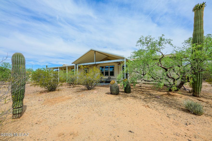 This stunning 3 bed, 3 bath home features OWNED solar and dual primary suites, offering flexibility and comfort for multi-generational living or guests. Tucked back off the street on nearly an acre (.94 acres) of natural desert landscape, this property delivers exceptional privacy and peaceful surroundings. Enjoy covered parking for up to 5 vehicles and numerous upgrades over the years including a new AC heat pump (2024), newer flooring in the living room and bathrooms, upgraded LED lighting throughout, and new ceiling fans with integrated LED lighting. The beautifully updated kitchen features new countertops, backsplash, sink, and a newer dishwasher. Two bathrooms have been refreshed with new countertops, and the primary bath includes a new sinks for a modern touch.