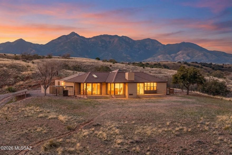 RARE TURN-KEY OPPORTUNITY:  Step back in time at 104 Douglas Lane in Sonoita, a striking mid-century modern home designed by Tucson architect William H. Cook. Set on a private road with unobstructed views to the north and east, this thoughtfully designed residence features brick floors, vaulted ceilings, skylights, and dramatic floor-to-ceiling windows that flood the home with natural light. Modern conveniences blend seamlessly with timeless architecture, including remote-controlled electric window shades, gas heat, a gas fireplace insert, and a Murphy bed for flexible living. The property is well-equipped for rural living with a fenced yard, horse stables, corral, chicken coop, RV hookup, and a two-car garage with storage. Outdoor living is exceptional with a hot tub, outdoor shower, and expansive patio perfect for enjoying Sonoita's dark skies and peaceful nights. Recent upgrades include a maintenance-free metal roof, new gutters and downspouts, new well pump, solar power system, and rainwater harvesting. Conveniently located near the Sonoita Crossroads, this fully furnished home offers privacy, character, and a rare opportunity to own a piece of architectural history in the heart of Arizona's wine country.