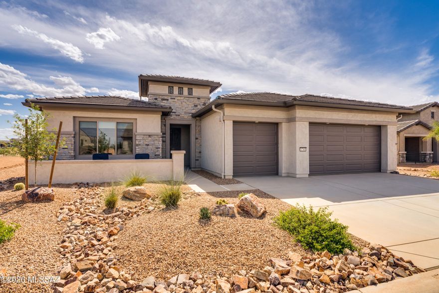 Less than 2 years new, this stunning 2024 Vienta model in Quail Creek is perfectly positioned on a premium lot backing to common area and walking paths, capturing scenic mountain views and breathtaking Arizona sunsets. Offering 2,353 sq. ft., this thoughtfully designed home features 2 BR, 2.5 BA, a versatile den, and a full 3-car extended-length garage. Impressive curb appeal with stacked stone façade and a welcoming front courtyard. Enter through a wrought iron security door into a bright foyer that opens to a spacious great room, complete with a stylish bar area and under-counter beverage cooler. The chef's kitchen boasts upgraded cabinetry with 41'' uppers, quartz countertops, tile backsplash, pantry closet, and a large island with apron sink, water purifier, and pendant lighting. LG stainless appliances include a 36" gas cooktop, vent hood, wall convection oven, and microwave. Interior features include luxury vinyl plank flooring in main areas, carpet in bedrooms, 8' doors and 5" baseboards throughout, and upgraded fans, lighting, and window treatments. The extended owner's suite captures mountain and sunset views, with a spa-like bath featuring dual vanity with undermount sinks, comfort height toilet, soaking tub, walk-in tile shower, and a large walk-in closet. A split bedroom design ensures privacy, with a guest bedroom offering its own en suite bath. The den with frosted glass French doors is ideal for an office, media or hobby room, or as an additional guest space, while a separate powder room provides added convenience for guests.  Laundry room includes extra cabinetry, utility sink, LG washer and gas dryer with pedestals, and an additional storage closet. Enjoy the extended outdoor living space with direct access to common area and walking paths--perfect for embracing the Arizona resort lifestyle.
