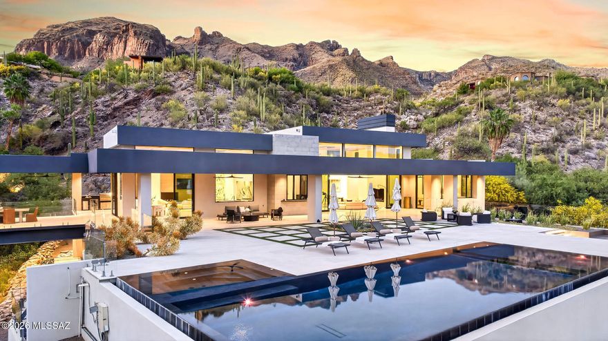 Set behind the gates of The Canyons, Tucson's most exclusive Foothills enclave, this newly constructed architectural masterpiece redefines desert luxury! Privately sited on 5 pristine acres, the estate captures breathtaking views while delivering a rare sense of seclusion just minutes from Tucson's finest amenities. Designed with obsessive attention to detail, walls of glass and soaring 18-foot ceilings blur the line between indoors and out. From dual onyx islands and bespoke finishes to a resort style pool and sky bridge, every element has been curated for those who demand extraordinary design, ultimate privacy, and world-class entertaining! 

Welcome to one of the most compelling luxury offerings ever presented in the Catalina Foothills, (continued) an architecturally significant estate in the prestigious guard-gated community of The Canyons! Widely regarded as the crown jewel of Tucson living, this enclave is synonymous with prestige, privacy, and estate-caliber residences. Yet even among such distinction, this newly completed home stands alone!

Privately positioned on five acres, the property delivers an experience rarely found: complete serenity, unobstructed desert beauty, and a feeling of being worlds away while remaining just five minutes from Tucson's finest dining, shopping, and lifestyle destinations!

From the moment of arrival, the home reveals its intention. Clean architectural lines meet warm, natural materials--limestone, onyx, granite, and custom wood detailing--creating a balance of modern sophistication and organic desert elegance. Inside, soaring 18-foot ceilings and expansive walls of glass invite the Sonoran landscape inward, flooding the home with natural light and framing panoramic mountain and city views.

Designed for both grand-scale entertaining and intimate living, the residence flows effortlessly through retractable glass walls that dissolve boundaries between interior and exterior spaces. Every room is purposeful. Every finish, intentional.

At the heart of the home, the kitchen is nothing short of a showpiece crafted for culinary excellence and social connection! Dual book matched onyx islands anchor the space, complemented by a suite of Miele and Thermador appliances, a fully equipped butler's pantry, and a dedicated bar service area. Whether hosting lavish gatherings or quiet evenings, the space performs flawlessly!

The primary suite is a private retreat of extraordinary scale and detail. Rich wood inlays, dramatic tray ceiling accents, and a statement fireplace create warmth and sophistication. The spa-inspired bath features a sculptural soaking tub, expansive walk-in shower, and luxurious finishes throughout. A dedicated "ready room" and a celebrity-caliber closet elevate daily living into a curated experience of style and ease.

Each guest suite is thoughtfully designed as a private haven, complete with ensuite baths and bespoke material selections that echo the home's refined aesthetic.

Beyond the living quarters, the estate offers a collection of amenities rarely found in a single residence. A climate-controlled wine room and cellar, private home theater, fully equipped fitness studio, and walk-in safe speak to both lifestyle and security. A 16-car garage provides space for the most discerning automotive collections.

One of the home's most unforgettable features is the "gold cave"--a striking nod to the area's rich mining history--delivering a one-of-a-kind conversation piece and experiential element that sets this property apart on a global scale. The sky bridge further enhances the architectural intrigue, connecting spaces in a way that is both functional and visually captivating.

Outdoors, the estate transforms into a private resort. A negative-edge pool and spa appear to spill into the desert horizon, surrounded by multiple lounge and entertaining areas designed for both day and evening enjoyment. Fire features, an outdoor kitchen, and expansive patios create an atmosphere that is at once vibrant and serene.

Above all, the privacy is extraordinary. The scale of the land, the positioning of the home, and the natural desert surroundings create a level of seclusion that is nearly impossible to replicate, especially this close to the city's best amenities.

This is more than a home. It is a statement. A sanctuary. A rare convergence of architecture, craftsmanship, and location designed for a world-class buyer who expects nothing less than perfection!