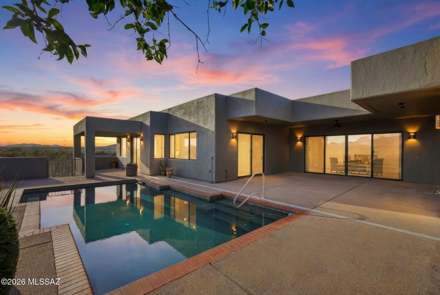 This is where luxury meets creativity, where every space was designed to be experienced—not just seen—and where the desert itself becomes part of the home's story. Before the mountains take your breath away, this home steals your attention. Hidden at the very end of a cul-de-sac in the gated sanctuary of Madera Shadows. As you approach, fresh exterior paint glows against the natural landscape while a softly trickling water feature sets a calming rhythm. Step inside to discover colored concrete floors that flow seamlessly throughout, perfectly complemented by fresh interior paint & abundant natural light. At the heart of the home, the chef's kitchen is both functional and artful, featuring a gas cooktop, tile countertops, custom hickory cabinetry, pot filler, and a generous walk-in pant Adjacent to the kitchen, a built-in buffet provides exceptional storage and effortless flow for entertaining. The great room is a show stopper with floor-to-ceiling views that frame the shimmering poolrecently serviced to remove calcium buildupand the dramatic Santa Rita mountain backdrop beyond. Anchoring the space is a gas beehive fireplace, paired with a custom TV console that mirrors the built-in buffet cabinetry for a cohesive, high-end finish. Center stage, a custom round dining table and chairsincluded with the saleinvite unforgettable gatherings beneath a one-of-a-kind art chandelier, a true statement piece valued at over $20,000, which conveys with the home. The primary suite is a private retreat designed for daily indulgence, offering dual vessel sinks, a soaking tub wrapped in tile, and a tiled walk-in shower. As you prepare for the day, an interior atrium window provides a gallery-like settingperfect for showcasing favorite artwork in natural light. Thoughtfully designed separate guest living quarters feature their own entrance to a private patio and the heated pool (with a new pool heater), and are independently climate-controlled with a mini-split systemideal for extended guests or multigenerational living. Outdoor living truly shines here. The extended covered patio is an entertainer's dream with a built-in BBQ, lounging areas, and even an outdoor tiled showerperfect after a swim under the desert sun. For creatives and hobbyists, the property offers an expansive workshop/studiofreshly painted and equipped with two industrial-sized kilns, served by two new evaporative coolers. Whether you're an artist, woodworker, or gearhead, this space opens endless possibilities. While the home includes a two-car garage, portions of the studio could be converted to additional garage space if desired. Additional highlights include:

Recently recoated roof

Refreshed desert landscaping

Solar panels for low monthly utility costs (leased; buyer to assume)

Termite warranty through Bill's Home Service

Kilns can be removed upon request

Set on 2.85 acres, this property offers rare peace, privacy, and room to breatheyet remains conveniently located. The home is not age restricted, and buyers may opt into GVR membership, unlocking access to fitness centers, clubs, classes, pickleball, arts, theater, and more.

This is more than a homeit's a lifestyle, a canvas, and a sanctuary. A place where luxury feels personal, views feel endless, and every detail tells a story.