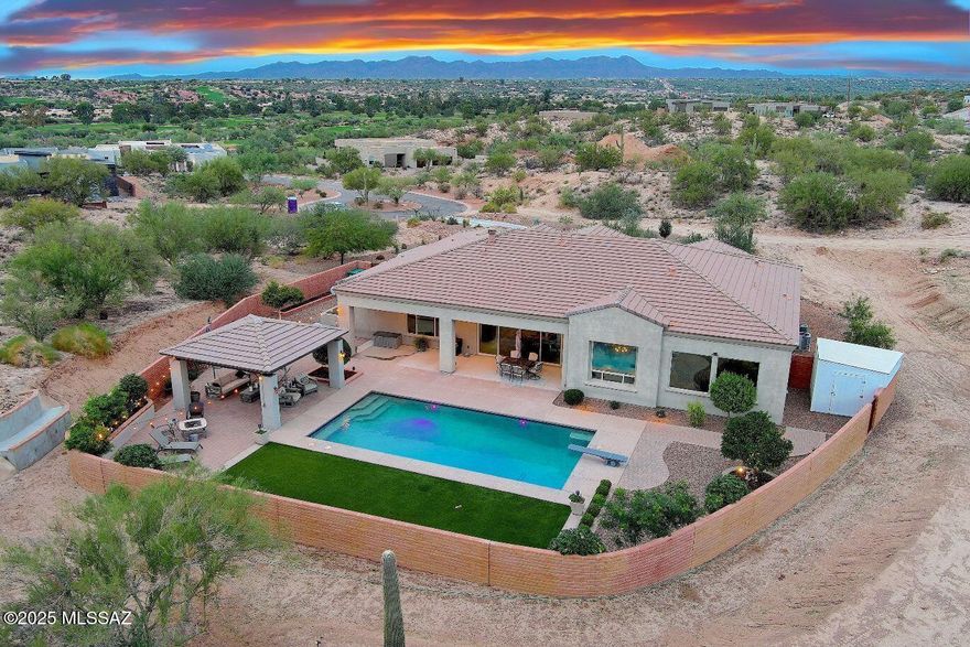 Welcome to the Hills at Tucson National. This is Gated Community living as it was designed to be enjoyed. This luxurious private 1.55-acre estate offers access to Tucson National World Championship Golf & 360-degree views of 3 mountain ranges, fairways & natural desert hillside landscape. A grand private driveway, pony wall courtyard, & extensive exterior landscaping complement the 9' deep sparkling pool with pebblefina finish, custom ramada retreat, artificial turf & citrus trees. The Great Room with 12'high ceilings, wood/gas stubbed, open floor plan with culinary inspired kitchen, commercial gas range, expansive entertainment island, honed granite, high-end appliances (separate icemaker) makes for easy living. Spacious NEXT GEN design M-in-Law full kitchenette suite & Jack & Jill suite