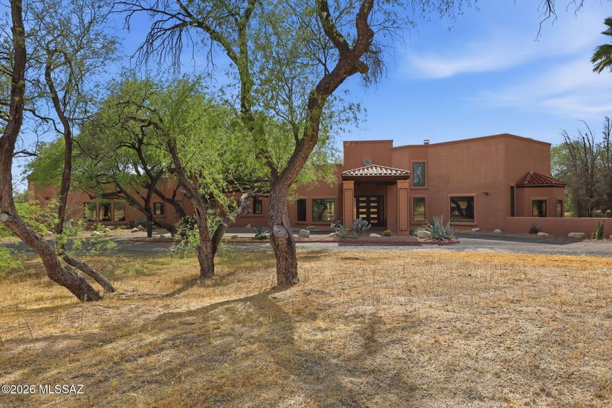 Nestled in the serene Bear Canyon enclave of Tucson, this stunning Southwestern contemporary estate offers a rare blend of architectural elegance and natural tranquility. Designed by renowned architect Frank Mascia, Casa Stella sits on a sprawling 3.49-acre lot. Even more compelling, the sale includes an adjoining parcel, bringing the total acreage to 7 total acres. This unique configuration offers exceptional flexibility, whether for building a second residence or guest house, creating a private compound, holding as a long-term investment, or potentially selling the additional lot separately in the future. Expansive windows fill the home with natural light, while scored concrete floors and four fireplaces add warmth and character throughout. The gourmet kitchen is a chef's dream, featuring granite countertops, designer stainless-steel appliances, mesquite cabinetry, and dual wine refrigerators. The primary suite is a private retreat, complete with a spa tub, marble surrounds, a cozy fireplace, and its own patio. Additional highlights include a four-car garage, gated entry, and a private well. This is a rare opportunity to own a piece of architectural artistry with added versatility, privacy, and investment potential in a peaceful, upscale setting.
