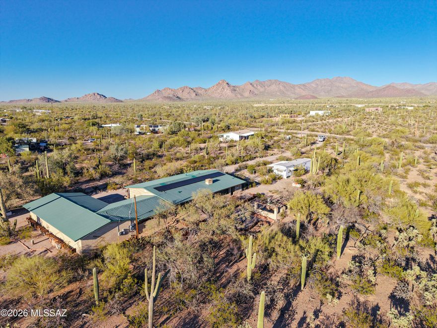 Set behind a wrought iron entry gate and surrounded by mature desert vegetation, this tranquil masonry residence offers an exceptional blend of privacy & refinement on its 4.42 acre, fully fenced lot. With 1,990 sq ft of thoughtfully designed living space, the interior highlights include 2 spacious bedrooms with potential for a third, 2 full baths including a recently remodeled guest bath w/custom tiled walk-in shower and granite countertop, tile flooring throughout, newer dual-pane windows, fresh interior paint, and a masonry fireplace with built-in mantle. Additional features include a 24' x 27' carport, plus an impressive 1,560 sq. ft. oversized garage and workshop w/electrical, plumbing, sink, 220 power. OWNED solar for LOW energy bills! Zoning allows for lot split potential too!