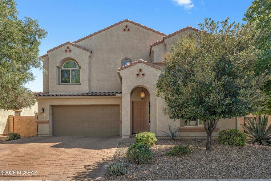 Welcoming and bright 3BD/2.5BA (2,574 sf) two-story home offers ample living space. Open concept plan boasts soaring ceilings, wrought iron staircase plus lower Den/office and laundry/powder rooms. Expansive lower living area lies off chef's kitchen w/ island, SS appliances and walk-in pantry. Upper level greets you with a large Loft. Private primary suite hosts ensuite bath w/ dual sink vanity, soaking tub, shower, walk-in closet. Bedrooms 2 & 3 share hall bath. Garage houses a water softener plus work area with upper/lower cabinets. Retreat outdoors to a covered patio overlooking a spacious yard with mature trees, desert plantings, block privacy wall and peeks of the Tucson Mountains. Fabulous Saguaro Bloom community features a park, playground, pool, spa, fitness center & walking trail.