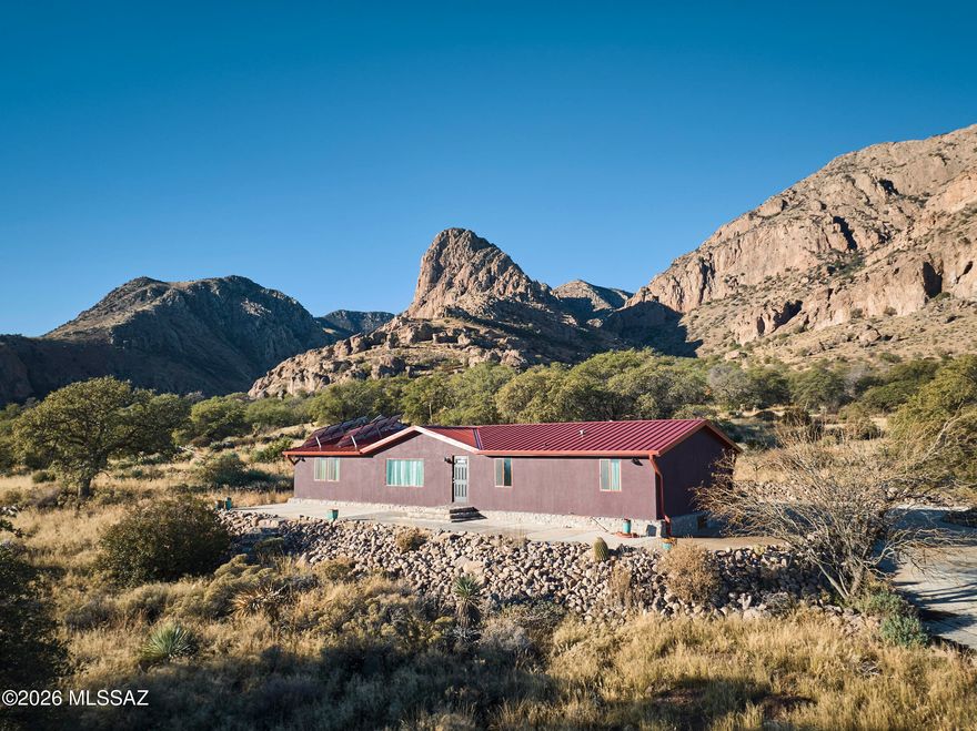 Wow!  What a view! MF Home on 40 acre lot bordering the Chiricahua Wilderness. 100's of huge oaks, meadow, canyon, wildlife, wildflowers, one of the most beautiful land parcels in Portal area with views of Mangus Dome. Magnificent 360Â° views, Peloncillos.  Bortle 1 & 2 dark night skies. Modern interior with updated laminate flooring,granite counters and stainless steel appliances in kitchen, this affixed manufactured home is stucco'd  and features a large porch and extensive rockwork around the home to expand entertaining to the outdoors.  New well, septic, and power to property, back up solar system, propane generator, concrete driveway from property line. Apache granary & ancient petroglyphs in NF adjacent to property. Property is fenced and shipping container may stay with property.