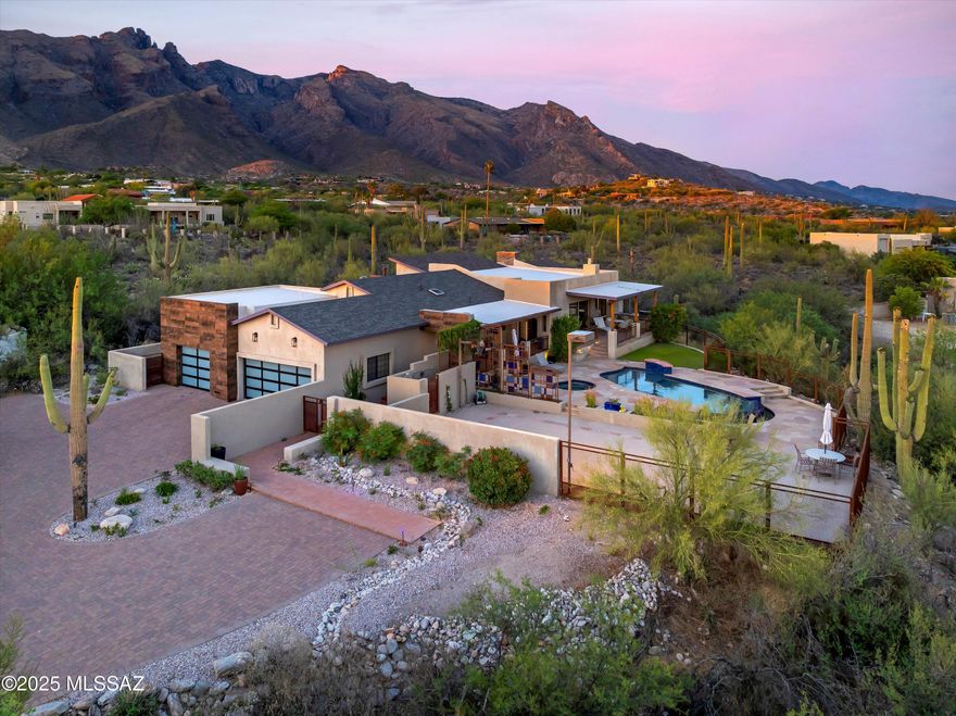 Experience the pinnacle of Catalina Foothills luxury living in this stunning custom home where dramatic mountain vistas create an ever-changing masterpiece through floor-to-ceiling windows. Situated on over an acre in the prestigious Foothills subdivision within District #16, this meticulously crafted 4-bedroom, 4-bathroom residence offers 3,218 square feet of sophisticated living space where the majestic Catalina Mountains serve as your private art collection, transforming from golden sunrise alpenglow to fiery sunset silhouettes. Tucked away for ultimate privacy yet strategically positioned in one of Tucson's most coveted neighborhoods, this property offers front-row seats to nature, walkability to high end restaurants and shops while maintaining the exclusivity of your own private sanctuary.
In 2014, that vision became reality through an extraordinary transformation designed by renowned Tucson builder Neil Murphy of "Tyson Murphy." This wasn't just a renovation approximately 85% of the home was torn down to the foundation and completely rebuilt, creating something truly spectacular. The only original element preserved was the cherished wood-burning fireplace, honoring the home's heritage while embracing a bold new future. Extensive 2025 renovations have further enhanced this meticulously crafted residence with impeccable attention to detail. The thoughtful split-bedroom floor plan flows seamlessly from the formal dining room through the great room concept living and family areas, complemented by a dedicated media room for intimate gatherings. The gourmet kitchen showcases premium appliances, gorgeous granite countertops, and custom cabinetry, all while those same spectacular mountain panoramas provide a constantly evolving backdrop through expansive windows - from the soft morning light illuminating saguaro silhouettes to the dramatic afternoon shadows racing across desert peaks. Rich hardwood floors throughout the main living areas enhance the sophisticated desert contemporary aesthetic while reflecting the ever-changing light show beyond the glass.
The crown jewel is the luxury primary suite wing, where floor-to-ceiling windows frame the Catalina Mountains like living artwork - imagine awakening each morning to sunrise painting the peaks in brilliant oranges and pinks, then unwinding each evening as the mountains glow crimson against purple desert skies. The separate sitting area with fireplace becomes your private viewing pavilion for nature's daily performance. The primary bathroom becomes a true retreat with its soaking tub positioned to capture desert views, geometric tile details, and sophisticated color palette that reflects the natural desert tones beyond the windows.
Three secondary bedrooms feature plush new carpet and modern closet doors, with two bedrooms sharing a convenient jack-and-jill bathroom configuration perfect for family living or guests. The fourth bedroom includes its own private ensuite, creating an elegant guest retreat. The bathrooms throughout exemplify sophisticated luxury with premium finishes - featuring elegant vessel sinks atop stunning marble countertops, custom floating vanities with sleek hardware, and dramatic oversized subway tile with designer mosaic accents. Modern glass-enclosed showers boast rainfall showerheads, built-in niches, and spa-quality fixtures, while skylights flood the spaces with natural light. A convenient powder room, recently remodeled laundry room with custom cabinets and pull-down folding station, and spacious three-car garage complete the home's thoughtful amenities.
Outdoor living reaches resort-caliber standards with the completely rebuilt pool featuring in-floor cleaning system, integrated lighting, negative edge design, waterfall feature, and extended play island - all surrounded by a stunning flagstone patio that captures the mountain amphitheater in every direction. Two built-in fire pits create perfect gathering spots for entertaining under star-filled desert skies, while the sport court with the option of a private pickleball court appeals to active lifestyles. Multiple seating areas are strategically positioned to capture those show-stopping vistas - from sunrise coffee on the north deck to sunset cocktails poolside, every moment becomes a celebration of Arizona's natural grandeur. The property's unique desert setting provides front-row seats to authentic Sonoran wildlife, where javelinas, deer, and bobcats regularly visit your windows, creating an intimate connection with the untamed beauty of the Catalina Foothills.
This completely renovated custom home on over an acre represents a rare opportunity to own a piece of paradise where sunrise and sunset become your daily companions, where mountain vistas serve as your ever-changing gallery, and where every day unfolds like a retreat in your own private resort. These are the views that define luxury desert living in the heart of the Catalina Foothills. Contact Oliver Realty today to schedule your private tour of this remarkable home!