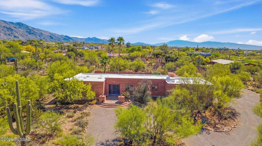 This adobe brick home is plentiful with quintessential Tucson charm. Located in the desirable Catalina Foothills 5 neighborhood within Catalina Foothills School District. Stepping in to the home you're greeted by yellow stained-glass panels, and a stunning archway leading you into the first of two living rooms. Both living rooms face the backyard with sliding glass doors to the backyard.  The backyard oasis has incredible views of the Santa Catalina Mountain Range and features true Tucson charm with a built-in adobe bench and original 1970's exterior light fixtures. Modern updates pair well with the original features in the home inside and out. Inside the home apart from the 2 living rooms, you'll find a formal dining room, 3 bedrooms and 2.5 bathrooms. Both guest bedrooms have doors leading to the exterior with one guest bedroom featuring a private seating area with mountain views. This home has been well kept with one owner for the last 40 plus years. The roof was replaced in March. Located within walking distance to Tucson's premier shopping district, La Encantada and the finest dining Tucson has to offer. Within Catalina Foothills School District and walking distance to Orange Grove Middle School. This home and community have so much to offer leaving little to be desired. Contact the listing agent for more information.