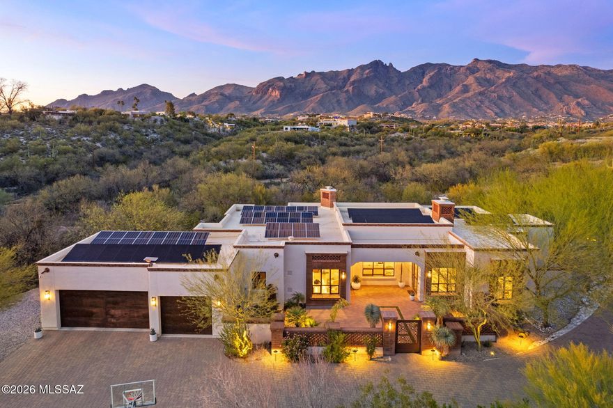 Located in the gated community of Colonia Del Sol in the highly desirable Catalina Foothills, this 2017-built Spanish Colonial style home sits on a spacious, private homesite with stunning mountain views. This home, built by renowned builder Jeff Franks, is within walking distance to Hacienda Del Sol Guest Resort and is located in the Catalina Foothills School District.
Designed for effortless single-level living with no interior steps, the thoughtfully designed 4-bedroom floor plan includes two guest suites with ensuite baths and walk-in closets.
The great room features dramatic beamed ceilings with hand-carved corbels, hand-plastered fireplaces in the dining and living areas, elegant travertine flooring, and floor-to-ceiling steel sash windows that fill the home with natural light. The gourmet kitchen offers top-of-the-line appliances, a large granite island, and a stylish bar area that opens seamlessly to the main living spaces, ideal for everyday living and entertaining.
Outdoor spaces include a welcoming front courtyard, expansive paver driveway with additional parking, refreshed landscaping with exterior lighting, and a private backyard retreat with a PebbleTec saltwater spool with automated cover.
Additional highlights include a 21 kWp owned solar system, newer exterior paint, Hubbardton Forge exterior lighting, reverse osmosis system with instant hot water at the bar, custom wardrobe cabinetry in the primary suite, upgraded carpet, and a 3-car garage with split AC and two EV charging outlets.
Enjoy privacy, energy efficiency, and refined desert living just minutes from premier golf, hiking, shopping, and the best amenities of the Catalina Foothills.