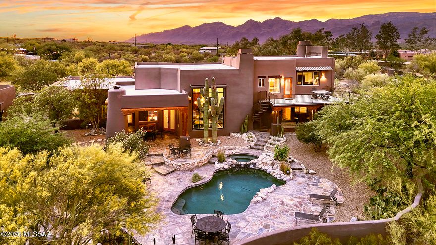 Nestled behind custom gates on over five private acres, this extraordinary equestrian estate is surrounded by sweeping mountain views and the natural beauty of the Sonoran Desert. A long, illuminated driveway welcomes you to a stunning custom Southwest residence and authentic hacienda-style casita, thoughtfully designed to blend luxury living with timeless desert charm. Equestrians will appreciate the exceptional setup featuring a 5-stall barn with tack room, two riding arenas, and convenient access to the scenic trails of Saguaro National Park East. Inside, the dramatic great room showcases soaring 24-foot ceilings, rich flooring, exposed beams, a striking slate fireplace, and walls of glass framing spectacular saguaros and mountain views. The updated chef's kitchen is truly the heart of the home featuring granite counters, hand-rubbed maple cabinetry, large center island, 6-burner cooktop, double ovens, Dacor warming drawer, walk-in pantry, casual dining, and bar seating. The luxurious main-level Primary Suite offers its own fireplace, cozy window seat, spa-inspired remodeled bath with standalone soaking tub wrapped in stacked stone, dual granite vanities, designer shower, concrete flooring, two walk-in closets, and private access to the patio and hot tub. The main level also includes additional bedrooms, laundry room, and oversized 3-car garage with newly coated flooring. Upstairs, a private guest retreat which is perfect for multi-generational living features a separate living area, bedroom, bath with teak wood flooring, and dining room that opens to a balcony perfectly positioned for stunning mountain views and moonrises. Outdoor living is equally impressive with a covered patio featuring wood plank ceilings, fireplace, outdoor kitchen and BBQ area, resort-style pool and spa, and expansive yard spaces. Equestrian amenities include a fully functioning 5-stall barn with tack room, two arenas, covered RV parking, hay barn, separate exercise room, and a 700-square-foot workshop with full bath. The detached hacienda-style casita offers incredible privacy for guests with authentic architectural touches, including a welcoming wood door imported from India, and its own private yard. This home is truly an exceptional desert sanctuary offering luxury living, privacy, and premier equestrian facilities in an unforgettable setting. Adjoining 4.21 acres to the east is available for sale.