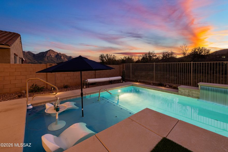Range Price. This Elegant, Feature Rich 5 Bdrm/4 Bath + Loft Home is Quintessential Tucson living front row to awe inspiring Sunsets & Giant Mtn Views in this well curated flr plan w/multiple mix use spaces decked out with fine finishes. Gorgeous Granite topped Kitchen counters & Grand Island lit w/stmt pendant lights.  Great Rm is coiffed w/timeless plank ceramic flooring, tall ceilings, ambient lighting, modern ceiling fans & picture windows looking onto Pool & Natural Desert beyond. Bdrm w/walk-in closet & Full Bath on 1st FLOOR! Amazing Pantry Rm, Butler Pantry & Drop Station. OWNED Solar, 4' ext garage w/EV Charger, Cat 6 throughout, Pantry Room, Recirc hot water, Grand Owner Shower & Spa Bathroom w/Lg Dressing Room. Read more ... Well appointed laundry room conveniently located upstairs has sink, 2 counters, hanging space. Each bedroom has a walk-in closet, but the Owner Suite Spa Bathroom & Dressing Rm is incomparable. So luxurious with Stunning Granite Counters on 2 Vanities set off by Espresso Cabinets & Large mirrors. The Lavish Shower has extended bench & full custom tile surround + it's own large opaque window. Owner Suite is generously sized w/inspiring Catalina Mtn VIEWS. Every Bdrm has those VIEWS! Well, it's all about that Oasis Backyard where chill time happens. Here, folks relax, fun is had, and respite is offered. Get lazy in the pool lagoon area, listen to the waterfall, view birds & desert flora. In-ground cleaning system & top quality Pentair pool equipment does the work. The Garage is tricked out too w/4ft EXT, EV charger, Wall Vac, pvc flr tiles, room for 3 cars + work area & storage! WOW!! This home has so many customized features. Plan to take your time to notice them all. Better yet, make it your own and enjoy them everyday!!