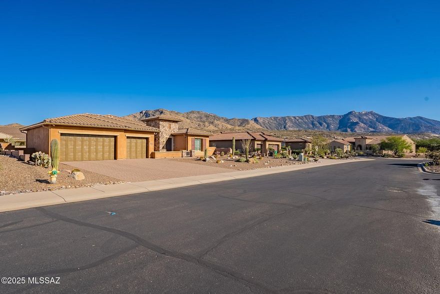 Desired east rear w/views of Catalina Mountains from extended back patio featuring a huge ramada, covered patio & raised sitting area. Versatile Canyon floor plan checks all the boxes. Open floor plan w/ Great Room, super Kitchen w/views to the outside living area, split bedrooms, wonderful master bedroom w/wood flooring, spacious master bathroom, large walk-in closet w/built ins, separate guest suite, den/office. Added bonus is the large sitting room/library or install a wall bed for additional guests. No need for a casita! Need room for an extended vehicle like a standard pickup. This 3 car garage with epoxy coating will accommodate it & includes space for a workbench. B/I vacuum, water softener, hot water recirculator . Exterior of the house painted & most windows upgraded in 2024 Neighbor with the pine tree has provided a letter stating that they will remove the pine tree approximately 2 weeks after close of escrow if the new owner wants it removed.
