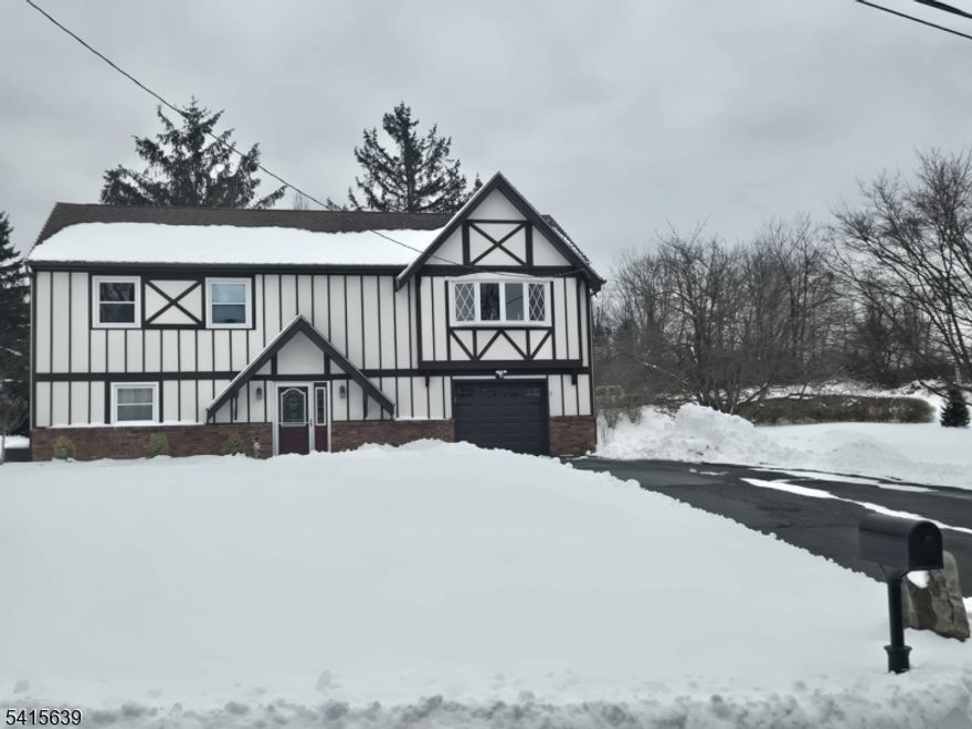 Stunning Move-In Ready Tudor on a Corner Lot. Welcome to this beautifully updated 3-bedroom, 1.5-bath Tudor home offering comfort, character, and modern upgrades throughout. Enter the lower level through an inviting foyer with convenient entry closets that lead into a warm and spacious family room, complete with classic wainscoting, fresh paint, and a pellet stove powerful enough to heat the entire home. This level also features a massive laundry room equipped with a new Samsung washer and dryer, abundant storage, and a thoughtfully placed half bath.The second level showcases an open floor plan filled with natural light. Enjoy a generous living area, a dedicated dining space, and a breathtaking newly renovated kitchen featuring stainless steel appliances, recessed lighting, granite countertops, a breakfast nook, and a gorgeous designer backsplash. Down the hall, you'll find a large primary bedroom, two additional bedrooms, and a beautifully updated tiled bathroom with double sinks. Every room is freshly painted and tastefully decorated.Outdoors, this property continues to impress. A brand-new patio offers the perfect setting for entertaining, while a deck and neatly lined arborvitaes provide privacy and serenity. Additional upgrades include new railings, new flooring, a new front walkway, updated fixtures, central air conditioning, a generator hook-up, and an upper-level ceiling fan.This exceptional home blends timeless charm with modern convenience truly a must-see.