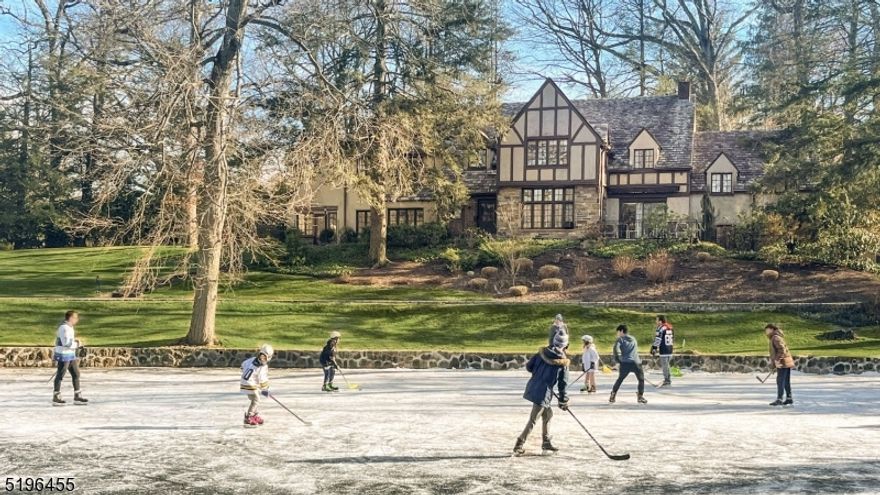 Don't miss this very rare opportunity to own a home in Short Hills with its own personal lake! Nestled up high on an idyllic 1.25 acres surrounded by rolling lawns and mature specimen plantings, this enchanting estate is a water lover's dream. The picturesque spring-fed lake is a beautiful addition to this stately residence, offering opportunities for boating, fishing, ice skating and ice hockey as well as scenic walks and breathtaking sunsets. This architectural gem with slate roof, stunning stonework and striking peaks has curb appeal galore and is truly a forever home. Historic details like oak paneling, rich hardwood floors and beamed ceilings are set against abundant windows that offer spectacular views and fill the home with natural light. The sophisticated main level greets you with an elegant reception hall and presents an expansive sunken living room with wood-burning fireplace and an adjoining sunroom. Across the hall, a spacious dining room with lake views greets guests in style. Other special features include an inspiring first floor office with fireplace, chef's kitchen overlooking the lake, a serene primary suite and 2-car garage. Outside the grounds beckon with tranquil spaces including a blissful bluestone patio overlooking the lake. This magical residence, on one of the most revered properties in all of Short Hills, feels far from the world yet is only blocks from Midtown Direct trains, world-class dining, designer shopping, top-rated schools and more.