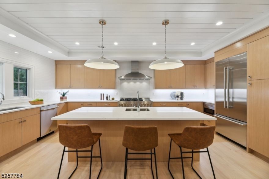 Discover an exquisitely renovated ranch, flawlessly crafted for its next owner. Designer tile finishes, custom built-ins throughout with an effortlessly flowing 5 bedroom, 5 full bath floor plan oozing abundant natural light at every turn. A chef's dream kitchen awaits, boasting a custom design with a spacious island, prep sink, ample storage, and a featured shiplap ceiling. Entertaining is effortless as the kitchen seamlessly flows into an expansive dining area and living room, showcasing a stunning floor-to-ceiling custom built-in shelf feature wall with a gas fireplace. The primary bedroom is a sanctuary with dual walk-in closets with custom built-ins and an ensuite bathroom with dual sinks and an expansive shower. Three additional bedrooms complete the first floor, each with its own designer en-suite bathroom adorned with intimate tile finishes, accompany a convenient laundry room on this level. The basement offers ample space for recreation, including a generous recreation room, a bedroom with separate entrance, a full bathroom, and three substantial leisure rooms with a bonus area. Outside, privacy trees, lush landscaping, and a custom patio beckon for outdoor enjoyment. Situated in Millburn's renowned school district, with easy access to downtown, effortless commuting to NYC, major highways, shopping, dining, and more, this home promises a lifestyle of unparalleled convenience and luxury.