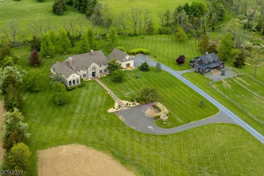 Nestled in the picturesque landscape of Tewksbury, this sprawling property spans over 20 acres of natural beauty. This estate boasts panoramic views of the distant countryside. Experience the epitome of luxury country living where every detail has been carefully curated to create a harmonious blend of elegance, comfort, and natural beauty. Along the long winding driveway you are greeted by a charming horse barn, complete w/3 spacious stalls, well-maintained paddocks, newly constructed riding ring.  This exceptional home features numerous updates including the kitchen, where rustic charm meets contemporary convenience, complete w/wood-burning fireplace. The adjacent dining room boasts a soaring two-story ceiling. the living room seamlessly flows into family room, both adorned w/ fireplaces & French doors leading to a quaint covered patio, offering breathtaking views of the landscape. A well-appointed office provides a quiet space for work, luxurious wet bar w/coffered ceiling sets the stage for effortless entertaining. A convenient full bath w/sauna on the first floor, while another powder room ensures convenience for guests. The second level features four generously sized bedrooms, including a lavish primary suite w/spacious dressing room. Outside, a second covered patio overlooks the meticulously landscaped yard. New partially finished basement w/plumbed full bath, plumbed kitchenette, office, and versatile space ideal for a gym/media. Views from covered porches. Generator.