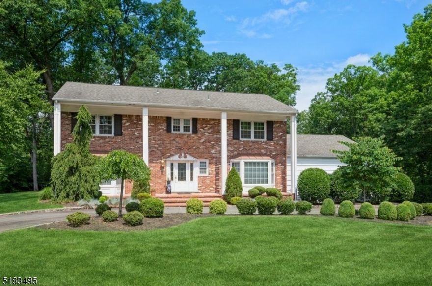 Stately Colonial home nestled on close to an acre of manicured property. From the architectural details, hardwood & marble flooring& spacious rooms to the stunning kitchen & finished lower level, this home is designed for comfortable living & entertaining. A semicircular driveway & beautifully manicured front yard invite you inside to a large, bright foyer w/a stone accent wall, graceful staircase& a powder rm. The spacious LR  includes a bow window & French doors opening to the FR. Get cozy around the double side corner fireplace set in a warm brick surround. Off the FR is a lovely sunroom, overlooking the deep & private back yard. The generous formal DR is perfect for hosting a crowd or just a few in elegant comfort. The gourmet eat-in kitchen is dazzling w/granite countertops & backsplash, high-end appl, oversized island, breakfast bar, 2nd sink & seating & stylish white cabinetry. Off the kitchen is access to the garage, an entry area to the back deck & a 1st floor bedroom complete with a WIC & full en suite bathroom. Upstairs you will find the primary bedroom suite, 3 additional bedrooms w/ample closets & a full hall bathroom. The large primary suite features a WIC & a full en suite bth. The finished basement level offers an enormous recreation space, half bathroom, dry bar area, an office/exercise room, a laundry room & lots of storage. This home truly has it all in an ideal residential neighborhood close to shopping, rest, the community pool, parks & Rt 10, 287 & 202