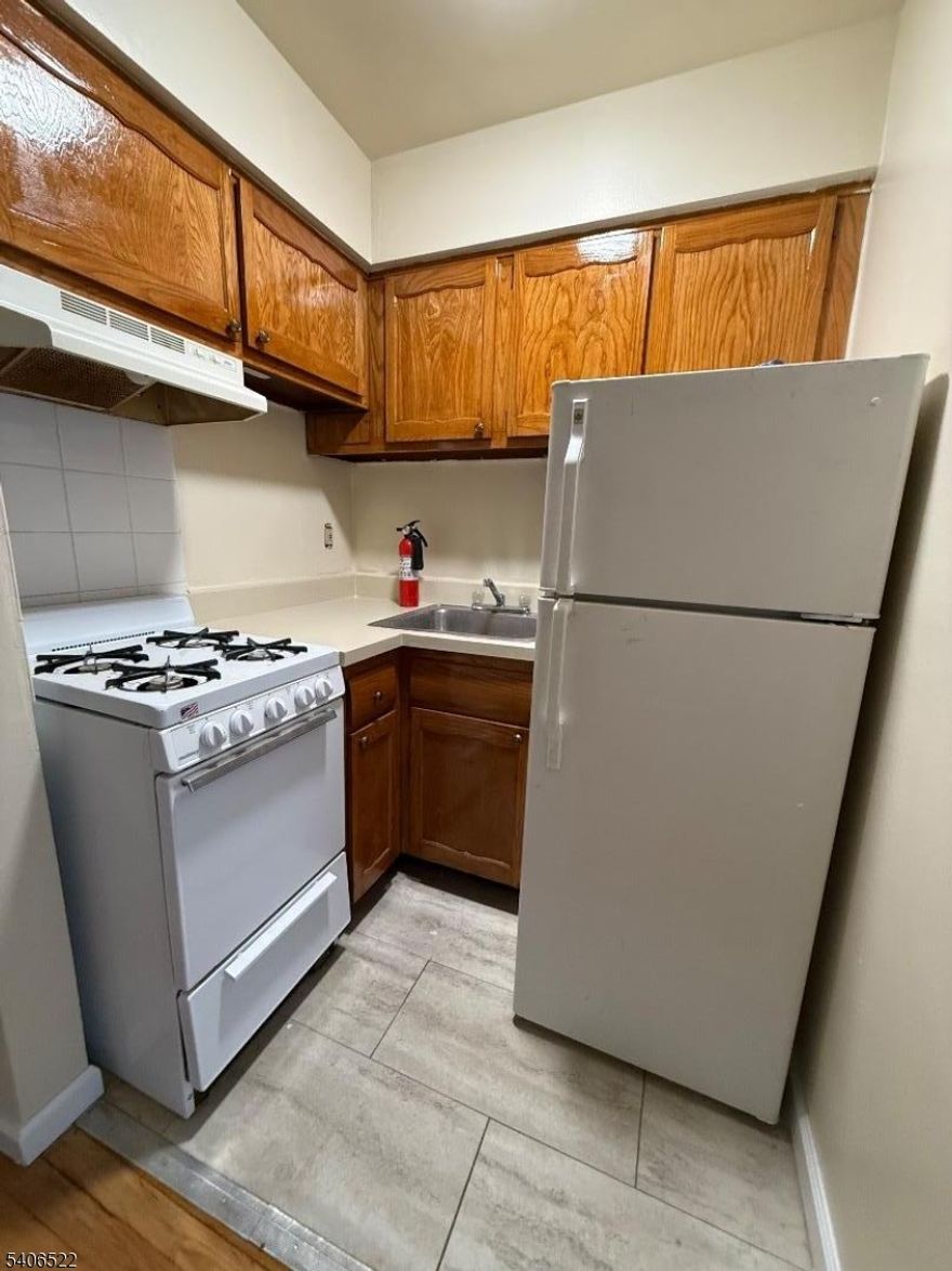 Spacious studio apartment featuring a galley kitchen with refrigerator, wall AC unit, fresh paint, tiled bathroom, and hardwood floors throughout. Includes parking and laundry room, conveniently located near transportation! Garage is additional if available!!