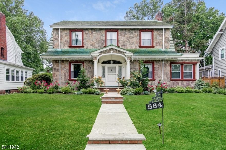 Timeless architecture & refined craftsmanship define this stately colonial w/ striking stone facade & exceptional curb appeal. A gracious, oversized center foyer sets the tone, accented by deep crown moldings, rich millwork & beautiful leaded glass windows that bathe the home in natural light while preserving its classic character. The LR offers a warm & inviting atmosphere, anchored by a wood-burning fireplace. Entertain in style in the elegant DR where a dramatic wood coffered ceiling creates architectural interest & an unforgettable backdrop for holiday gatherings & dinner parties. The updated EIK blends charm & functionality, featuring SS appliances, abundant cabinetry, generous counter space & walk-in pantry for impressive storage. A comfortable Den provides flexible living space ideal as a media room, playroom, or library while a full bath on the main level offers convenience for guests. The 2nd floor hosts 4 well-proportioned BRs, each w/ ample closet space, along w/ a full hall bath. A walk-up unfinished attic presents outstanding potential for future expansion - private primary suite, studio or bonus room tailored to your needs. The finished LL significantly expands living space & versatility. Enjoy a recreation room for casual gatherings, a full bath, private office & an additional room ideal for au-pair, or guest arrangements. A summer kitchen adds further convenience & flexibility. 1 block to Jitney to NYC trains; close to shops/parks/restaurants.