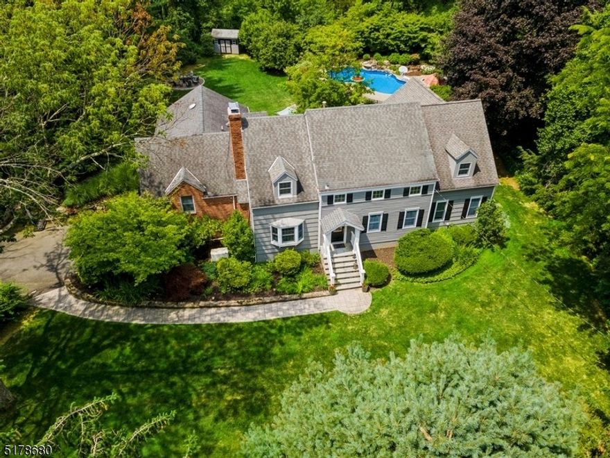You'll be captivated by this sprawling Custom Colonial nestled on over an acre in a bucolic yet posh Morris County Twp. Set amidst nature on a dead-end street, this home offers easy access to sought-after schools, golfing, a beach club & NJ Transit Midtown Direct train line to NYC in nearby Morristown. This stunning home offers a spectacular backyard including a partially covered patio bordered by lovely gardens & a sparkling in-ground pool & hot tub. The elegant interior features rich hardwood flrs, crown molding & trim details, windows galore offering abundant natural light & beautiful views of the grounds, many built-in elements & generous entertaining spaces inside & out.On the 1st level a welcoming foyer, large LR w/a fireplace & an elegant formal DR, a large office or family rm w/custom built floor-to-ceiling bookshelves & cabinets, plus a full bth. Gourmet kitchen w/granite counters, extensive custom cabinetry, workstation, SS appliances, center island & a sunlit breakfast area w/a bow window bench. Off the kitchen a powder rm, laundry rm & a sunrm w/French doors to the patio. First floor guest bd includes an en suite bth, WIC & walkout to the patio. Generous-sized primary bd on the 2nd floor incl. en suite bth, a sitting rm & French doors to a Juliette balcony. An addt'l Bd w/en suite bth & 2 more Bd that share a full Bth. The finished basement a huge rec-room, a wine room, powder rm, pantry & access to the garage, storage space off the garage & an exercise room.