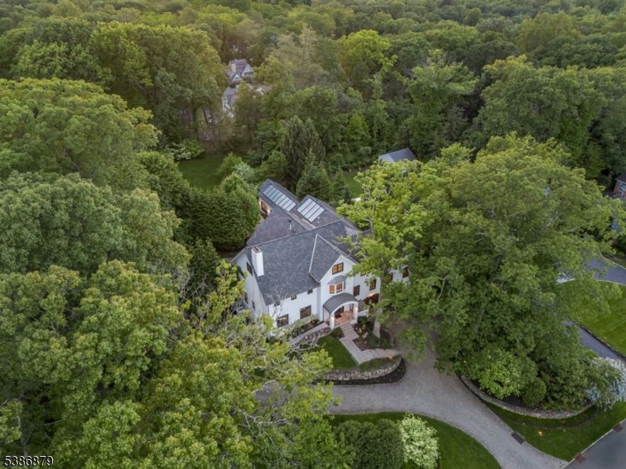 EXPANSIVE MODERN MASTERPIECE ON COVETED NORTHSIDE OF SUMMIT DELIVERS THE PINNACLE OF CONTEMPORARY SUBURBAN LIVING! Early 20th-c. home completely reimagined in 2011 into 9 Bed/7.2 Bath showpiece sure to impress all who cross her threshold. Grand circular driveway leads to home sitting entirely above ground on 1.8+ acres of lush greenery w/ stone walls, privacy hedges, ample parking areas, attached 3-car garage & fenced-in backyard w/ multi-tiered concrete tile patios. Museum-like Grand Foyer sets stage for artisan ambiance that features soaring ceilings, floor-to-ceiling mirrors, beautiful lighting, exposed ductwork and sleek steel & frosted glass doors. Living Room w/ concrete fireplace & built-in shelves. Dining Room's massive sideboard & two china closets are an entertainer's dream. Family Room open to expansive Eat-in Kitchen w/ 2 islands, sinks, high-end appliances (Sub-Zero fridges, Wolf wall ovens, Miele dishwashers) & fabulous storage space in sleek lacquer white frameless cabinetry. Sitting Room, Sunroom w/ fireplace & Outdoor Kitchen w/ Wolf grill & fridge complete living space on this level. Primary Suite worthy of 5-star resort w/ sprawling boutique-like dressing room/closet/bath & shower room. 4 Beds on 2nd Level, 3 on 3rd and 2 on Lower Level create ample room to retreat. Lower Level continues resort feel w/ 75' indoor lap pool, hot tub, exercise room & wine room. Discerning buyers w/ an eye for minimalist design will cherish the chance to call 60 Fernwood home!