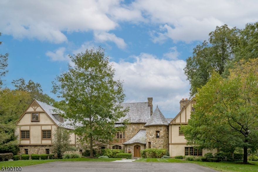 An Exquisite Country retreat on the Bernardsville Mountain overlooking panoramic views of the Somerset Hills. Built in 1935 and extensively renovated and expanded over the years, this three-level home contains six bedroom, five full baths and a powder room. Highlights of the interior include layered and custom-crafted crown moldings, quarter sawn random width oak floors, numerous built-ins, five wood burning fireplaces with gas starters, leaded glass windows and some radiant heated floors. The views are enjoyed by all the main rooms. The kitchen and heart of the home offers upper-end appliances and a pizza oven built into fieldstone surround. The dramatic great room is set under 28ft vaulted and original wood beamed ceiling. A separate wing consist the primary suite with beautiful views and elegantly mantled limestone fireplace, walk-in closet and an en-suite spa bathroom. Two more bedrooms, full bath and laundry room finish this floor.  Second level present two more bedrooms will full bath. The ground floor offers a second custom full kitchen with upper end appliances, an en-suite bedroom, exercise room and another full bath. Mudroom with custom built-ins leads to garage access. The exterior is genuine stucco with a slate roof.  Impressive outdoor enhancements include the pool and stone pool house (unfinished interior), gardens, covered bluestone terraces, stone walls and professional landscape. You will be captivated by the landscape and all the beauty of this stone estate.