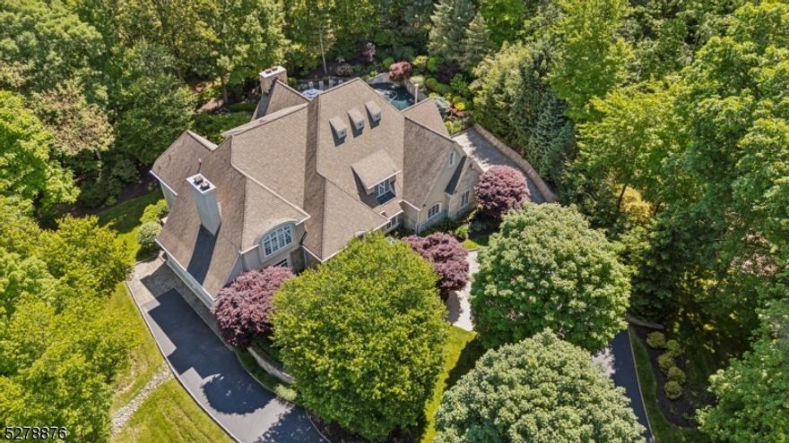 25 Knightsbridge, nestled lakeside in Watchung's "Burnheade" neighborhood, offering a private lot enveloped by the natural beauty of surrounding trees. This property is a serene retreat just minutes from Route 78. You'll be enchanted by the grand entry hall, featuring soaring ceilings, herringbone-patterned hardwood flooring, & custom millwork. With 5 bedrooms, 6 full and 2 half baths. The chef's kitchen is a culinary delight, equipped with a separate Sub Zero refrigerator & freezer, 2 Miele dishwashers, a Dacor stove & wall oven, Sub Zero refrigerator drawers & limestone-granite counters. The solarium overlooks your backyard oasis, featuring a heated saltwater pool. The great room has a floor-to-ceiling stone fireplace, coffered ceilings, & a wet bar, creating an amazing space for gatherings. The elegant office/library is highlighted by a gas fireplace & panoramic views of the private property. The finished walk-out lower level has an additional apartment-style living space, complete with its own entrance, living room, kitchenette, ensuite, & laundry closet. The LL (with 2 full baths) also features a wall of windows & doors that connect to the stone patio, offering a seamless indoor-outdoor flow for hosting large gatherings. For added convenience, the property boasts an elevator, a security system, & three laundry room areas, ensuring practicality for daily living. The 14-zone heating system, 7-zone A/C & 5 fireplaces add to the allure of this residence. Welcome home.