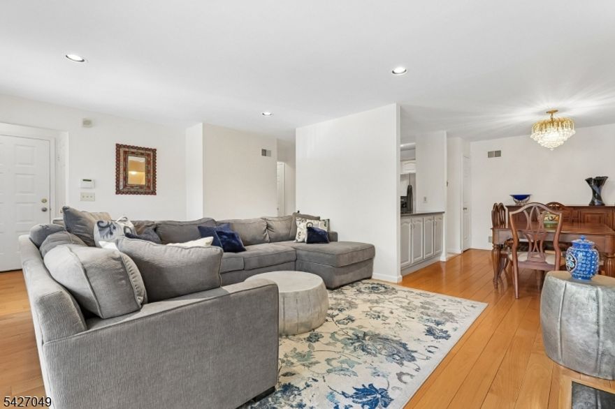 Nestled in the scenic Hill community, this sprawling, multi level, 4 bedroom, 3.5 bath townhome offers a bright and sun filled open floor plan with generous living space and a versatile, thoughtfully designed layout. The main level includes a formal dining room and a bright living room with a gas fireplace, perfect for both everyday living and entertaining. The white kitchen is appointed with granite countertops, tile backsplash, and a center island with seating, along with a convenient powder room and direct access to the attached garage. Just off the kitchen level, a private upper level features the primary suite with en suite bath along with a second bedroom also offering a full bath en suite. A landing area provides flexible space for a TV lounge or home office. Continuing, the ground level offers two additional bedrooms, a spacious recreation and family room, and a full bath with washer and dryer, creating an ideal setup for guests, work, or extended living. Enjoy seamless indoor outdoor living with a deck off the main level and a patio on the lower level, both accessible through sliding doors. Residents enjoy access to community amenities including a clubhouse, tennis and pickleball courts, and a pool, along with nearby jogging and bike paths. Convenient to shopping, dining, and NYC transit, and located near Turtle Back Zoo and the South Mountain Recreation Complex.