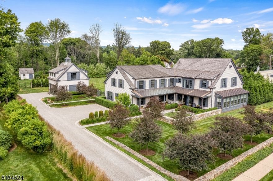 EXTRAORDINARY NEW LISTING!   What began as the home site of an antique colonial has been transformed into a modern country retreat by the owners of Orchard Hills Design and Construction. Built in 2006, with subsequent additions in 2009 and 2018, the current homeowners brought their professional expertise and discerning eye for luxury details to the entire process.  Every inch of this stunning home has been finished with only the highest quality materials, fixtures and finishes. The end result is swoon worthy and a rare offering in any real estate market.   A flawless floor plan unfolds from the entry foyer into a sunny living and dining room, where Pollack fabric covered walls are framed with reclaimed barn wood beams, and a custom steel and glass wall partitions the rooms.  The primary suite is reminiscent of a a bespoke boutique hotel with a fitted dressing room, plumbing fixtures from Samuel Heath, and a handsome bedroom with views of the front courtyard. Four additional bedrooms and four unique full bathrooms with designer tile and polished nickel fixtures complete the second floor.  A first floor guest suite was designed for multi-generational living and offers an office, full kitchen, living/dining room, bedroom, dressing room, full bath, powder room and a partially finished lower level with a sunlit sitting room and second laundry room.  A detached two-story garage has space for two cars and a second floor that was framed and plumbed for future finished space.