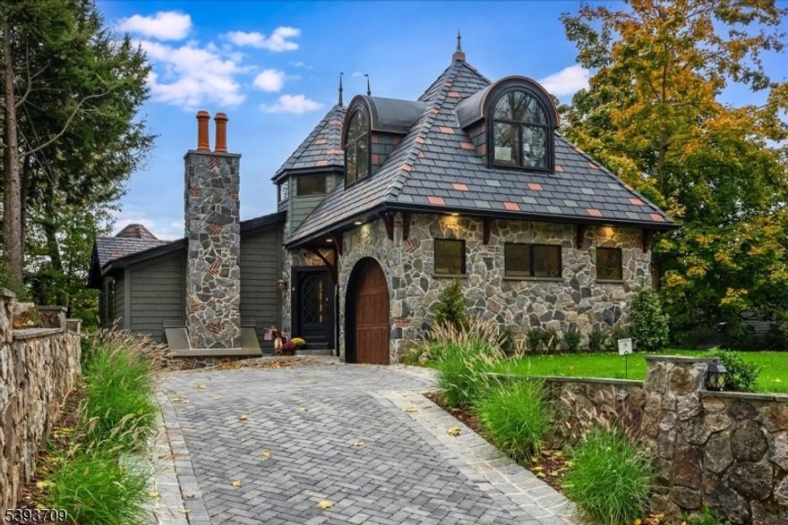 LAKEFRONT- Expanded renovated home featuring high end finishes and a three level elevator! The exterior features extensive high-end materials from the early Lake Mohawk style stone work to the lifetime warrantied synthetic slate roofing tiles to the solid cedar support brackets, no expense was spared to ensure this home would truly be one-of-a-kind. A 2 story entry foyer welcomes guests with elegance and provides access to three bedrooms, including a fairy tale primary suite hidden behind a secret door! The primary suite features a spacious full bathroom w/ double vanity, soaking tub, glass enclosed tile shower and private water closet. Dual walk-in closets, an incredible lake view and a three level elevator make this primary suite second to none. A fourth bedroom, office and powder room can be found on the second level. The ground level of this fascinating property is highlighted by a gorgeous kitchen, complete with a quartz topped center island, high end appliances, beverage refrigerator, butlers pantry with second dishwasher, powder room and laundry room.  Sunken family room with amazing lake views and elevator access and a living room / dining room combo with a cozy gas fireplace make this ground level the perfect place to entertain guests. Step outside to take in the lake views from either of the two decks or the completely covered lower patio complete with lighting and ceiling fan. 2 Car garage w/ one 12.5' ceiling height, perfect for a car lift! 3 bed septic