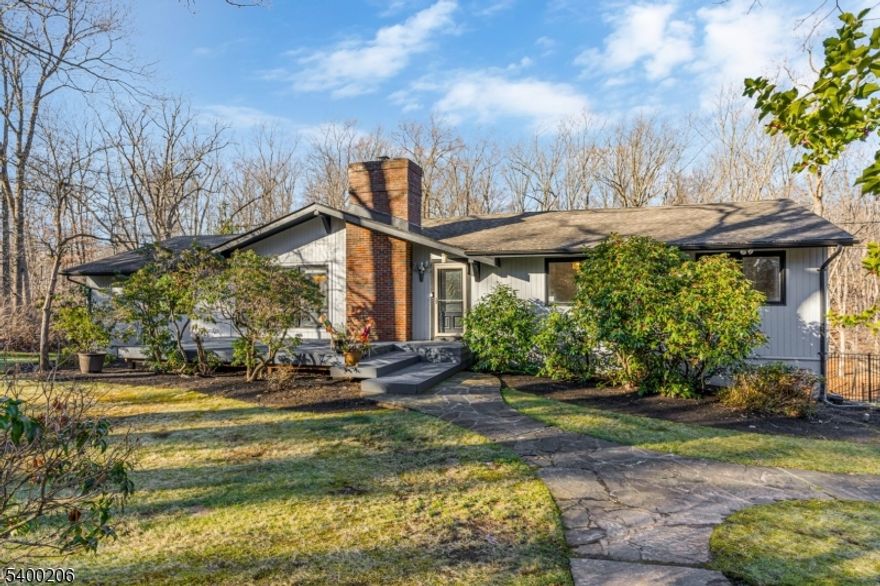 Beautifully updated and expanded 4-bedroom, 3.5-bath custom ranch set on a spectacular private, park-like fully fenced in property in highly desirable Warren Township. This sun-filled home offers true one-floor living, an open-concept layout, and exceptional indoor/outdoor flow perfect for both everyday living and entertaining. The main level features a spacious great room with cathedral ceilings and a wood-burning fireplace, seamlessly connected to the chef's kitchen with center island and direct access to the expansive deck overlooking the fully fenced yard. The primary suite includes a renovated en-suite bath, while two additional bedrooms share a beautifully updated hall bath. A separate guest suite with a private full bath and its own outdoor balcony provides ideal space for visitors, in-law suite, or home office. The large finished walkout lower level includes a second wood-burning fireplace, laundry room/half bath, office or gym area, access to the oversized two-car garage, and additional unfinished storage space. With hardwood floors throughout, updated kitchen and baths, a flexible floor plan, and easy access to major highways and direct NYC bus service, this home combines comfort, convenience, and exceptional location. All within the top-rated Warren Township school district this property is not to be missed.