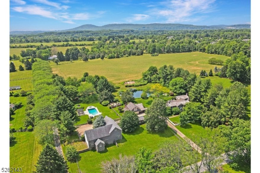 The beauty of Far-A-Field Farm shines with a rich patina that has been cultivated over the last 275 years of the property's stewardship. Believed to have been built in 1750 as the original farmhouse for the Farley farm, this sophisticated property has been meticulously restored and updated by its Owners with an eye to marrying the beauty of traditional finishes with modern conveniences. Thoughtfully sited in a retreat-like setting nestled outside of the historic village of Oldwick, Far-A-Field Farm is oriented to maximize enjoyment of the striking natural beauty of the bucolic Tewksbury countryside. Anchored by a colonial-era vintage farmhouse benefitting from thoughtful expansions over the years including a detached garage with a separate workshop and second-floor office space, this unique property provides both a haven and a place of entertainment for its Owners and guests. Admiring butterflies in the gardens, relaxing by the elegant swimming pool, exploring the vintage barn, daydreaming in a boat on the pond, or walking the perimeter of the crop fields at Far-A-Field Farm, one easily forgets how close this retreat-like home is to the bustle of New York City, a feature distinguishing it from equally-beautiful, yet less-accessible properties and making it perfect for use as either a full- or part-time residence. The property currently benefits from the low property taxes associated with farm assessment and is suitable as a hobby farm.