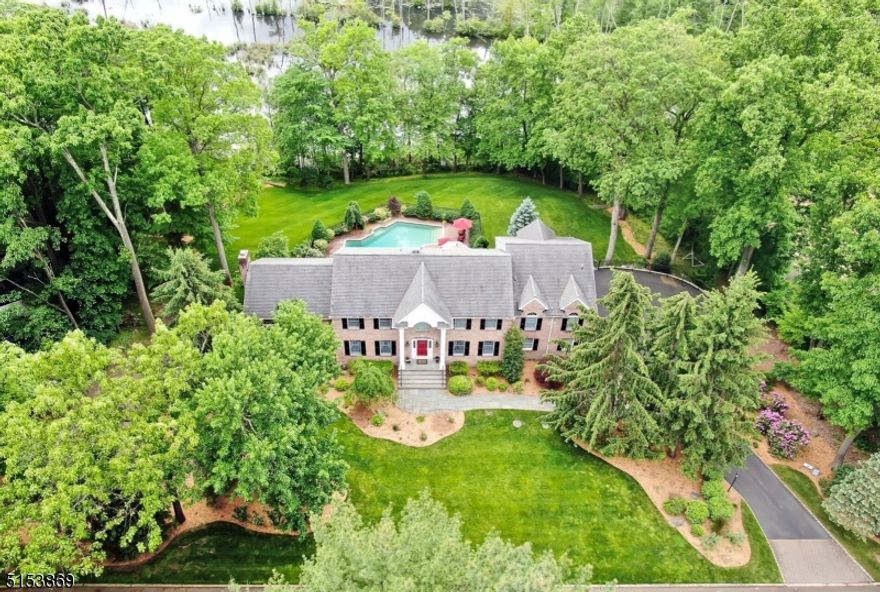 Classic and stately brick front colonial nestled on gorgeous acre property with heated saltwater pool and breathtaking outdoor oasis! Stunning private rear yard with views of the mountains, nature area and reservoir! Beautiful updates throughout! Foyer leads to formal dining room with detail moldings. A wall of French doors open into the private library/living room. The elegantly renovated kitchen by Ulrich features a large center island with granite/bar seating, glass cabinetry, top of the line appliances & door to multi level deck overlooking the pool. Kitchen flows to the family room with year round views from the wall of windows & glass door to deck. Great Room addition features tremendous space with vaulted ceiling and gas fireplace. 2nd floor primary suite steps down to an amazing room with soaring ceiling, large Palladian window, 2 walk-in-closets plus a spectacular spa bath. 3 additional bedrooms, 2 more fully updated baths and spacious laundry room complete the 2nd level. Lower level is fully finished with an outside entrance, media & entertainment area with wet bar, surround sound, storage, full bath & bonus walkout guest suite. What a beauty!