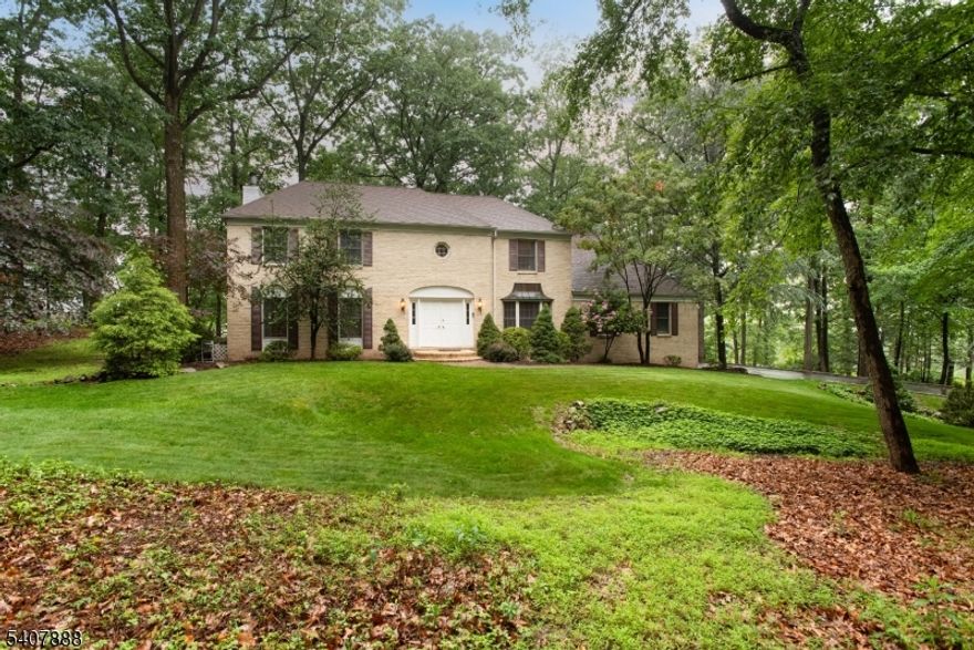 Welcome to this serene, nearly one-acre property set in the Watchung Mountains. The expansive first floor features hardwood floors refinished in 2017 and a beautifully remodeled kitchen (2017) with stainless steel appliances, rich wood cabinetry, and a 9-foot granite island ideal for cooking, baking, and entertaining. The kitchen opens seamlessly to the family room, offering backyard views and direct outdoor access.  The dining room w/bay window brings in plenty of natural light.  French doors connect the family room and living room, allowing flexible use of space by leaving them open for an open floor plan or closed for privacy if needed.  The main level also includes a fifth bedroom with ensuite bath currently used as a home office, a spacious laundry room with backyard access, and a separate mudroom with built-in desk and shelving. Upstairs, the luxurious primary suite features a sitting room, private office, two walk-in closets, and an updated ensuite bath with oversized shower and soaking tub. Bedrooms two, three, and four are generously sized with ample closet space, complemented by a beautifully updated main bathroom. The walk-out basement offers a recreation room, exercise room, and abundant storage. Outdoors, enjoy a park-like backyard with a stunning wood deck backing to Warrenbrook Golf Course. Conveniently located minutes from Warren town center shopping and dining, close to NJ Transit options, and within a highly regarded school district.