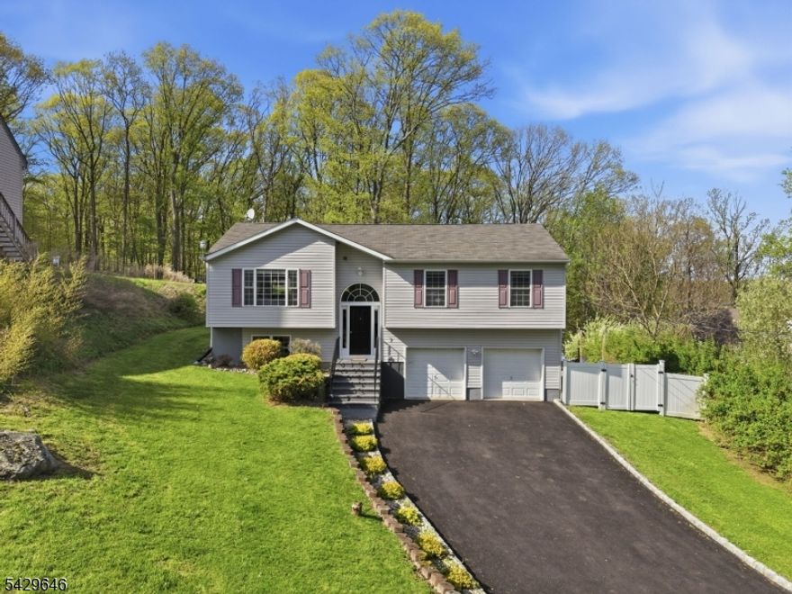 This beautifully updated bi-level sits on a private wooded lot in Hopatcong. The sun-filled main level features gleaming hardwood floors, an open-concept living and dining area, and a spacious kitchen perfect for everyday living and entertaining. Upstairs offers generously sized bedrooms and an updated full bath.The walk-out lower level adds exceptional bonus space with a large second family room, custom wood bar, and game area that's ideal for hosting, relaxing, or creating the ultimate hangout space. Step outside to your own backyard retreat with a deck, paver patio, and a huge fire pit! Car enthusiasts, hobbyists, and outdoor lovers will appreciate the massive 25x25 oversized 2-car garage with plenty of room for vehicles, tools, toys, and storage. Just minutes from Lake Hopatcong, local parks, dining, and major commuter routes. Move-in ready and packed with space, updates, and versatility. Come see it for yourself!