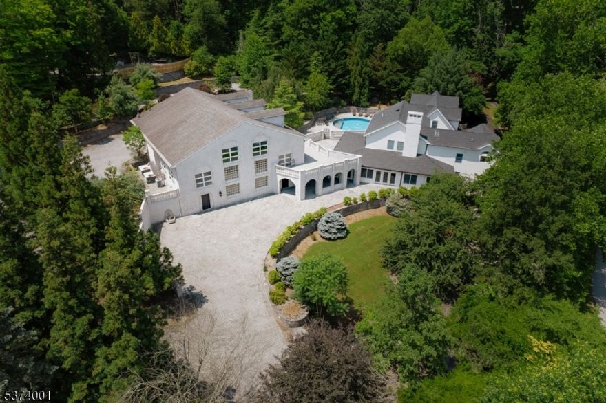 A true statement estate, 154 River Rd is a distinguished riverfront retreat where timeless architecture meets refined modern living. Set on beautifully hardscaped grounds with tranquil river views, this fully redesigned 4BR, 5.5BA home offers a rare blend of elegance, luxury, and exceptional amenities. One of the estate's unmatched appeal is its remarkable 4500 sq ft stone structure originally designed as an indoor professional-grade basketball gym. This expansive space is ideal for training, recreation, private events or adapting for business use permitted by the Twp, it offers endless possibilities with your finishing touch. The main home features a spacious open layout ideal for entertaining. The chef's kitchen showcases a 10-ft quartz island, with matching counters and backsplash, a hidden walk-in pantry, and a dedicated beverage bar. Sun-filled living areas flow seamlessly into a large rec/playroom, private movie room, and a custom 8 seat bar in the sunroom. Upstairs offers a thoughtfully designed layout with two separate staircases. One wing offers a secluded guest suite with a large BR, balcony, sitting room, and full BA. The opposite wing features 3 spacious BR's: one with a walk-in closet and spa-like en-suite; the remaining two BR's share a Jack & Jill BA. A 2nd floor laundry room adds convenience. Outdoors, enjoy a sparkling pool, scenic courtyard, and well-appointed entertaining areas surrounded by striking architecture.