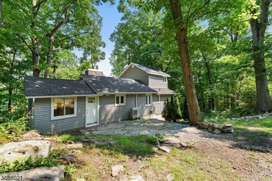 Natural beauty all around you in this charming home w/ 2 BR, 1 bath, & an amazing deck w/ seasonal lake views! This cozy cottage is nestled on nearly an acre of private property just minutes to East Highland Lake where you can enjoy boating, fishing, kayaking, beaches, & all this lake community has to offer. From the front patio, step inside to an enclosed porch w/ an entry directly onto the back deck & another into the spacious kitchen w/ ample counter & cabinet space & a breakfast bar. The open layout in the living/dining room showcases a beautiful floor-to-ceiling stone fireplace & windows all around overlooking the lush greenery. The main level continues with a full bath & primary bedroom w/ a walk-in closet. There is a second BR upstairs, & a full basement offers great potential for expanding.