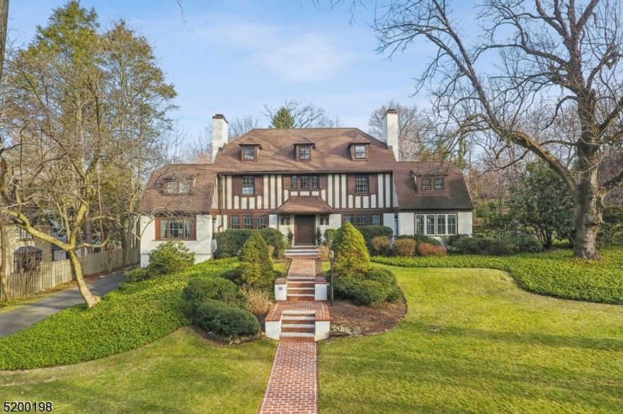 MAGNIFICENT 1911 ENGLISH TUDOR * OLD SHORT HILLS * A wonderful opportunity to acquire a grand residence that is both historic & current. Majestically perched atop 1.03 acres w/ open lawns & formal gardens, this home has both the pedigree and elegance of Old Short Hills & has been renovated for today's modern living. Replete w/ beautiful architectural details -- a front-to-back foyer, grand staircase, 5 fireplaces, oak paneled library/office & gorgeous woodwork throughout! You can entertain in the LR, host in the elegant DR, relax in the sun-filled FR or simply reflect by the window seats. State-of-the-art kitchen has custom cabinetry, SS appliances (Wolf, Sub-Zero, Bosch), center island w/ granite counters & bar seating, desk area, wet bar, mudroom & adj breakfast rm w/ built-in banquet & access to the large brick entertaining patio. Upstairs, 5BRs include spacious primary suite w/ spa-like bath: double vanity, soaking tub & glass shower. LL: lg rec rm, BR, full bath & laundry rm. Bonus Space over the garage is perfect as a separate office, home gym or whatever you may need. CAC, underground sprinklers, outdoor lantern lighting & generator for peace of mind. The lush grounds are extremely private w/ flowering trees & perennial gardens (room for a pool). Just blocks from top-rated schools, incl. Glenwood Elementary & Short Hills train station w/ direct trains to speedily bring you home frm NYC. This spectacular estate is both an architectural masterpiece & a private sanctuary.