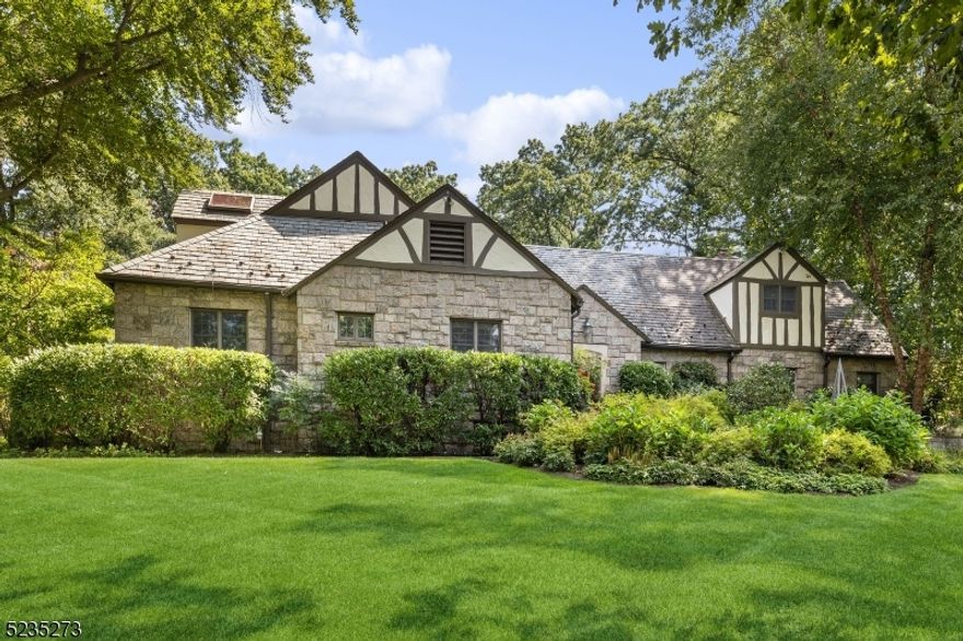 ONE OF A KIND ESTATE HOME with Vermont granite stone exterior offering a lovely blend of period details & contemporary finishes & scaled for gracious entertaining or intimate gatherings. The chef designed kitchen features top of the line custom cabinetry, dual islands with quartz, a wood-burning pizza oven, Wolf range, Viking appliances & both breakfast & skylit sitting areas. Grand living spaces include a vaulted-ceiling living room with a wood-burning fireplace & French doors opening to an extensive blue stone patio. The dining room, also with French doors opening to patio, can accommodate 12. The family room boasts a beautiful cherry wood bar. Convenience reigns on the 1st floor with 2 offices, bedroom suite, laundry & back staircase. The primary suite is a luxurious retreat with a wood-burning fireplace, large walk-in closet & spa-like bath. Renovated bathrooms, generator, landscape lighting & security features enhance modern living. The basement offers rec space, tons of storage & full bath. Outdoors, enjoy nearly an acre of property with a sports court, perennial gardens, hot tub & stunning blue stone patio. Add'l features include a 2-car garage, slate & composite roofing & underground sprinkler. Nestled near Yantacaw Brook, Tuers & Brookdale Parks & convenient to U Montclair's appealing restaurants, shops, & NYC direct trains, this estate elegantly blends architectural splendor, modern comforts & an enchanting outdoor oasis. An extraordinary living experience awaits.