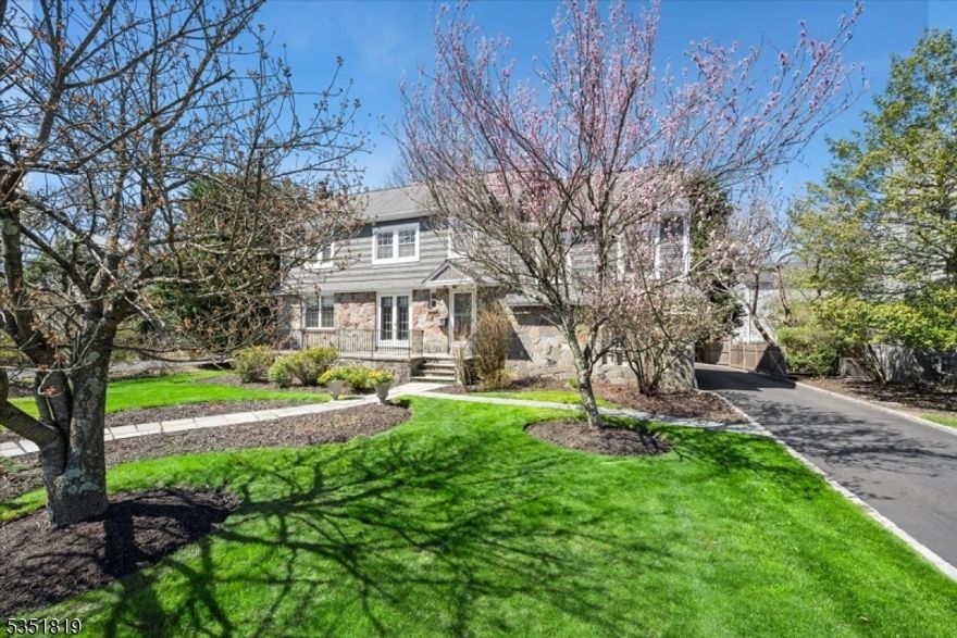 Welcome to a place where timeless elegance meets everyday comfort, a beautifully crafted Colonial tucked away in one of Summit's most cherished neighborhoods. From the moment you arrive, you're greeted by lush, manicured gardens & a sense of peace that only comes from a home designed with care. Inside, sunlight spills across rich hardwood floors & classic millwork, creating an inviting flow perfect for both gatherings & quiet moments. A striking stone fireplace anchors the living room, while French doors open to a charming front porch. The heart of the home is a chef's kitchen featuring custom wood cabinetry, gleaming quartz countertops, high-end appliances & a decorative tin ceiling a space that inspires creativity. Adjacent is a formal dining room, an office with built-ins & sliders to the deck. A convenient mudroom/laundry area & powder room complete this level. A spacious family room just steps from the main level offers a cozy, versatile space for movie nights, playtime, or relaxing. Upstairs, the tranquil primary suite features a beautifully appointed bath with dual vanity and walk-in shower. A second ensuite bedroom provides comfort & privacy, while 2 additional bedrooms are joined by a stylish Jack-n-Jill bath. The finished lower level features a large rec-room with plenty space for a home gym, yoga or music studios. Enjoy a fenced-in backyard with deck, patio & a peaceful creek. Just minutes to downtown Summit, top-rated schools, and Midtown Direct trains to NYC.