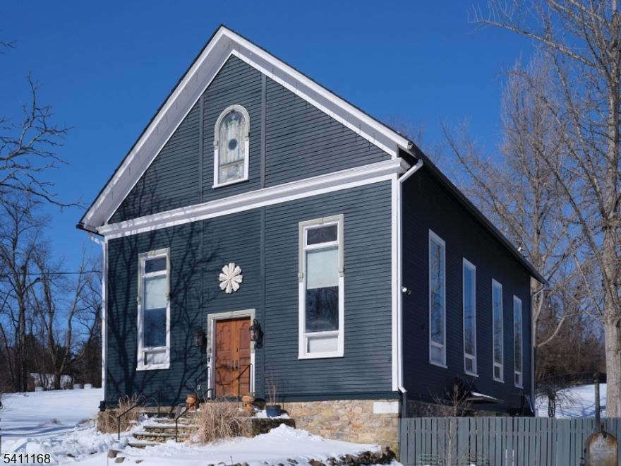 Set on over two serene acres, this beautifully restored circa-1880 former sanctuary has been transformed into a one-of-a-kind residence blending historic character with modern comfort. Park-like grounds feature lush perennial gardens, brick walkways, a tiered fountain, in-ground pool, pergola-covered patio with freestanding stone fireplace, and the original ?outhouse? potting shed.French doors open to an open-concept kitchen, dining, and family room w/radiant-heated floors, two-foot-thick exposed fieldstone walls, hand-hewn beams, and custom built-ins. The updated chef?s kitchen offers granite countertops, a 9-foot center island, stainless steel appliances, farmhouse sink, custom cabinetry, and pantry. A full bath with dramatic glass-enclosed stone shower and a vintage pedestal sink salvaged from the Metropolitan Opera House completes this level.The former sanctuary now serves as a stunning vaulted living space with floor-to-ceiling original stained glass windows, wide-plank pine floors, beadboard ceilings, chestnut moldings, and a soaring brick fireplace with custom built-ins. This level includes a guest bedroom and a recently added modern bathroom with glass-enclosed shower.Two staircases lead to the private primary bedroom loft featuring an antique iron railing, oversized dressing closet with hand-carved barn shutter doors, and access to a full-length unfinished attic. Energy-conscious with discreet solar panels.