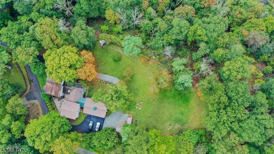 Welcome to this one-of-a-kind restored and updated Farmhouse - located on an unusually picturesque mountain top lot within desirable Watchung. Offering 4,449 sq ft of living space, this home blends country living with modern updates. New flat roof 2026 on original part of house. A traditional sitting porch sets the tone, leading into charming interiors filled with natural light. The formal living room features a fireplace, bay window and outdoor patio access, while the dining room showcases period details, bow windows and built-in cabinetry. The expansive kitchen with exposed beams, granite counters and S/S appliances opens to an English conservatory overlooking private, mountain views, perfect for relaxing or entertaining year-round. Upstairs you'll find five bedrooms with updated bathrooms. An attached two story home office/studio provides the ideal space for work, study or play with large sunlit first and second floor rooms and a full bath. - Hardwood floors, thoughtful finishes, and abundant windows create warmth throughout. The property also boasts a three-car heated garage connected by a breezeway and mature landscaping that enhances the picturesque setting. Conveniently located near shopping, dining,and commuter routes, this home offers both tranquility and accessibility. This exceptional Watchung residence combines character, space,and style offering timeless appeal and modern comfort.